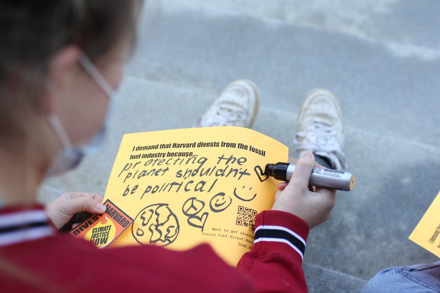 A student makes a sign at a Divest Harvard rally in front of Widener Library in November 2020.