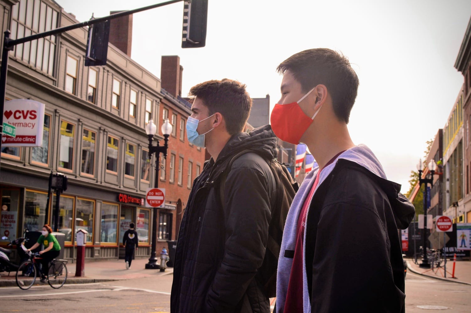 Jacob Fernandes ‘24 and Bach Nguyen ‘24 stand on the curbside to cross the street after picking up their 2024 Register from 2 Brattle Street Wednesday afternoon.