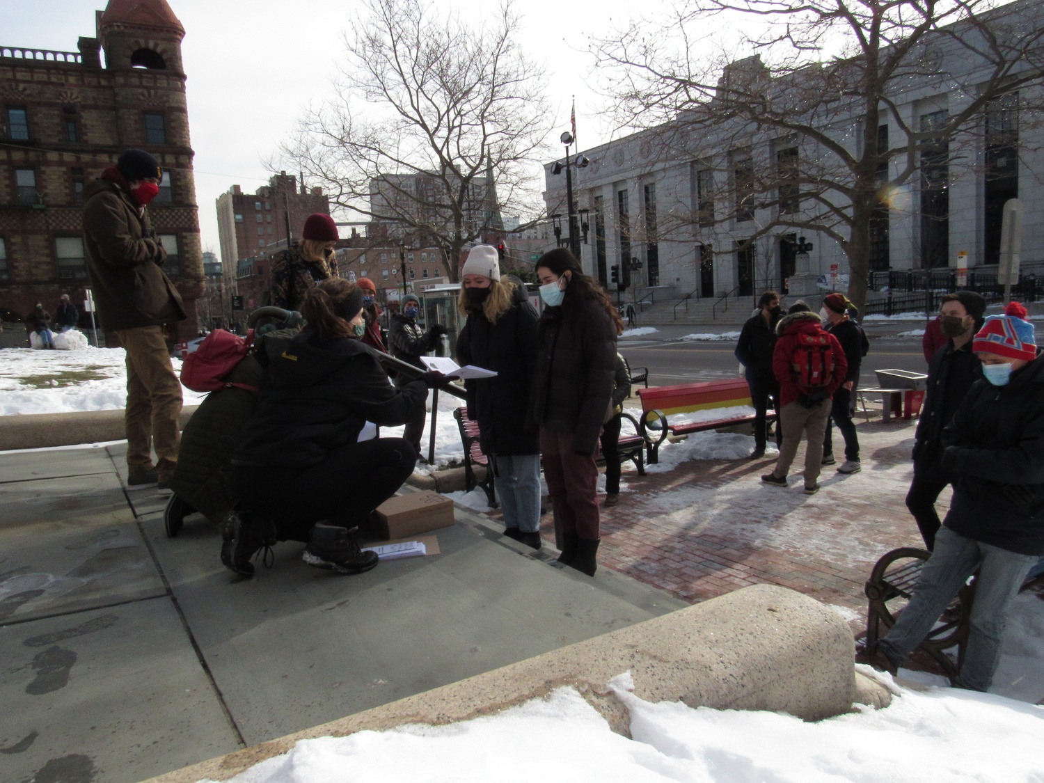 Project Right to Housing organizers hand out pamphlets calling on Cambridge residents to deliver public comment at Monday's City Council meeting in support of creating non- congregate shelter spaces.