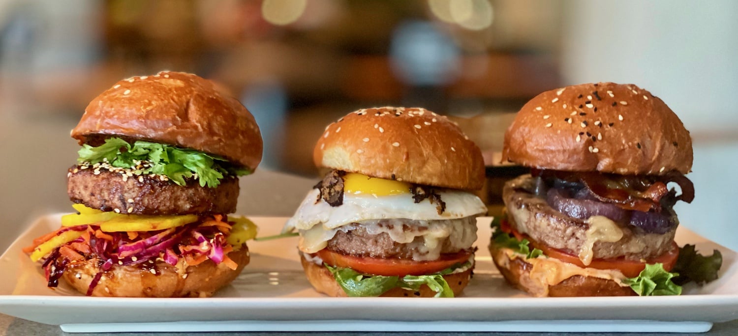 A trio of burgers on display at Nu Burger, a new burger venture that re-opened as a ghost restaurant after originally being in Time Out Market Boston.