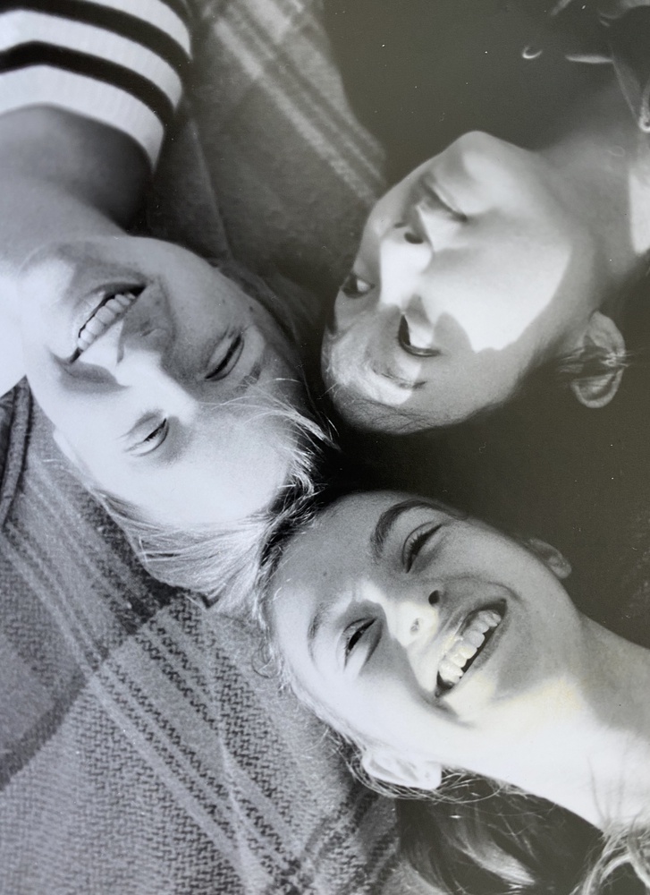 Three close friends from high school, lying down at a playground.