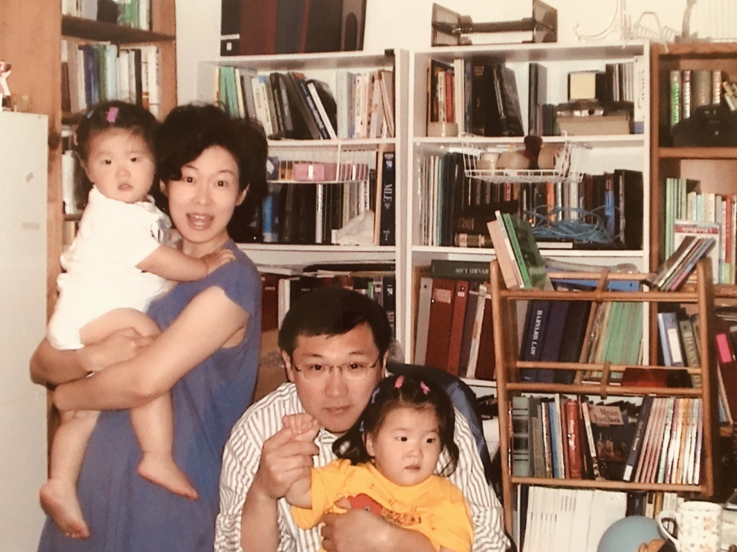 Isabella B. Cho ’24 (right) poses for a photograph with her twin sister and parents in their apartment on Prentiss Street in Cambridge.