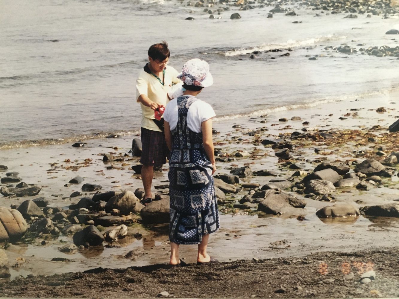 Isabella B. Cho ’24’s father and mother wade in the water during a trip away from their studies.