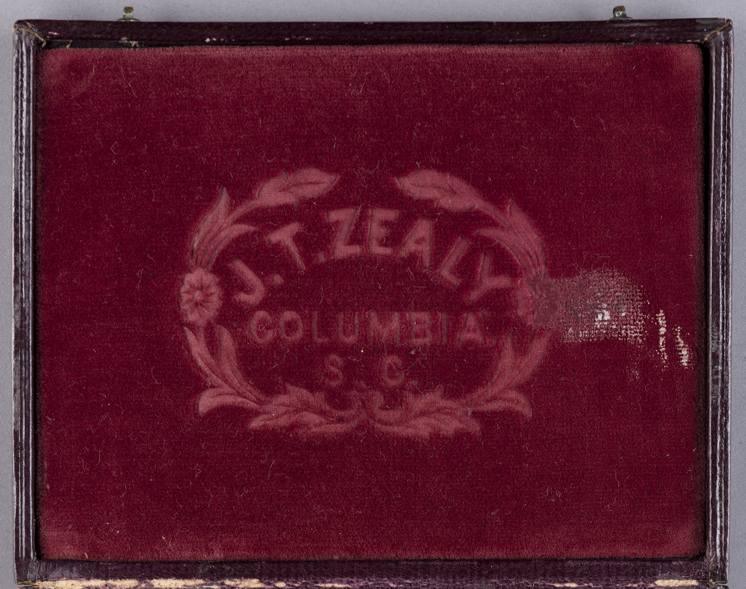 The insignia of J.T. Zealy imprinted in the case holding the daguerrotype of Renty, commissioned by Louis Agassiz. 35-5-10/53037.
