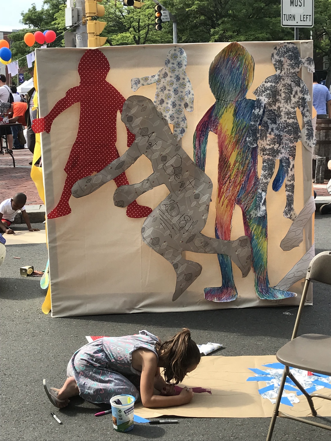 In 2018, Christina M. Tedesco invited members of the Somerville community to make life-sized paper dolls of themselves, collecting them into a temporary mural called "Traces of Bodies."