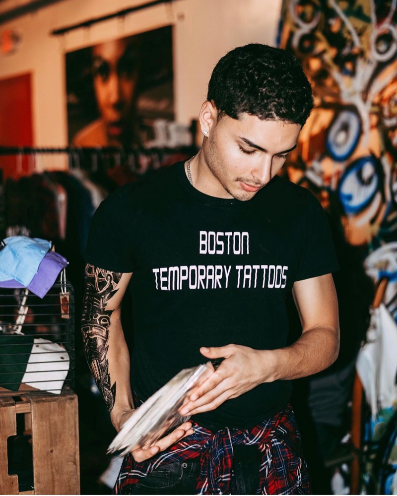 Juan S. Cardenas-Duque sorts through orders for his business, Boston Temporary Tattoos.