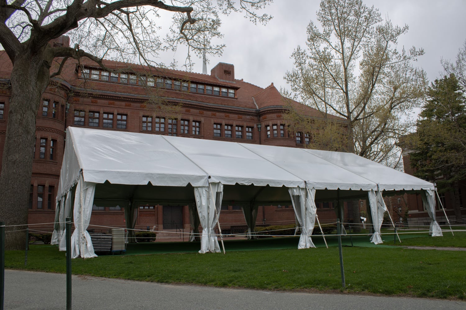 The College is experimenting with in-person and hybrid courses to develop best practices for in-person teaching and learning, with some classes being held in a tent behind Sever Hall.