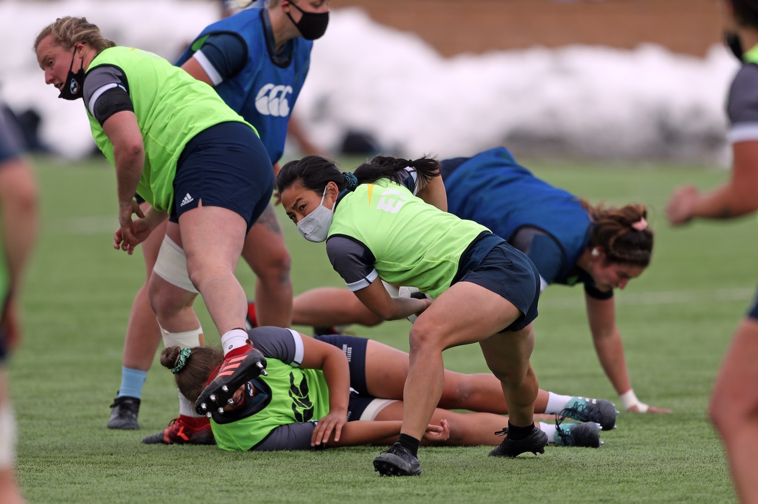 Shelby Lin '14 side-lunges in a warm-up session with USA Rugby. Covid-19 safety protocols, such as mask-wearing on the field, are in full effect.