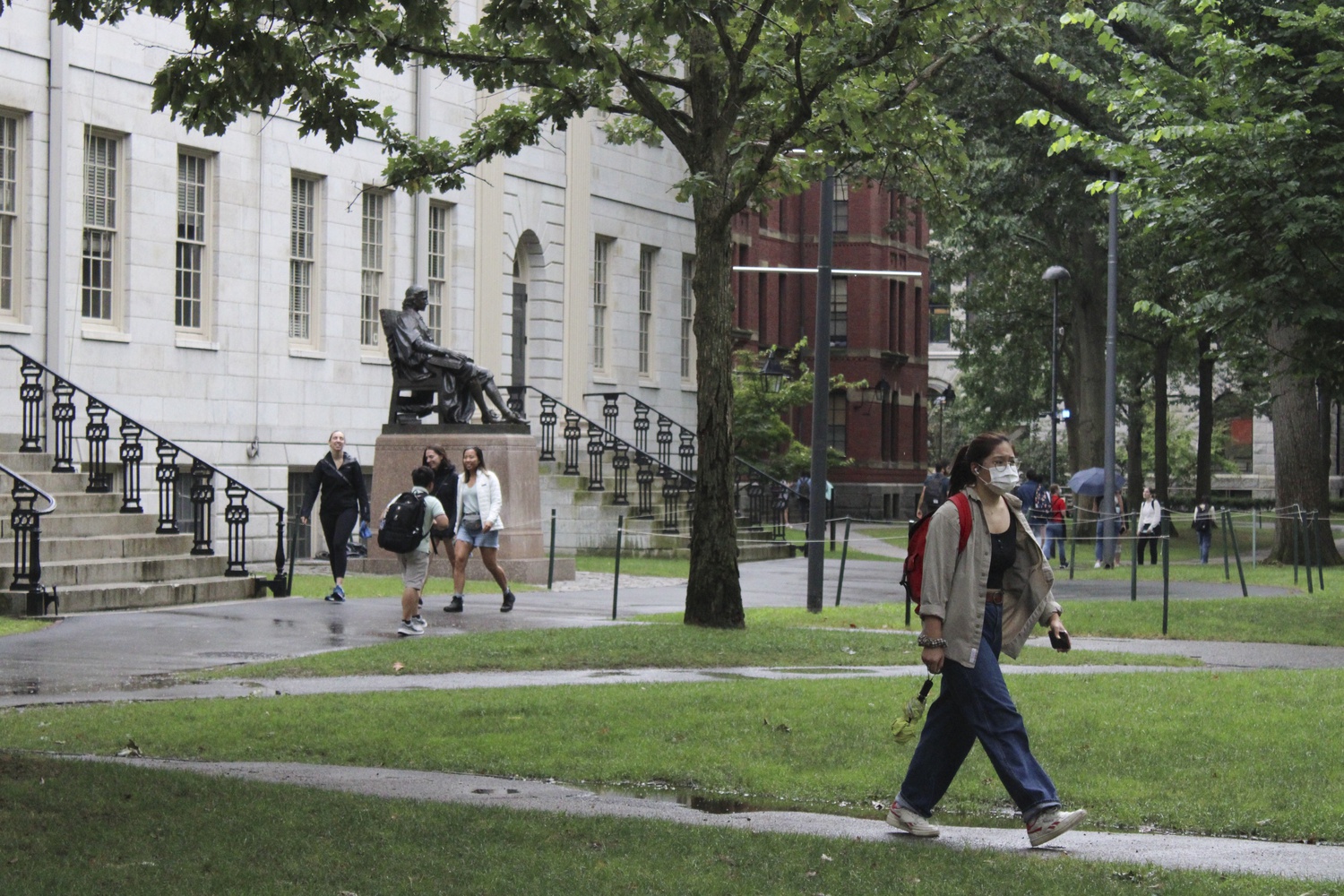 Students walk through Harvard Yard on the first day of classes Wednesday. For many students, the day marked the first time they received in-person instruction in more than a year.