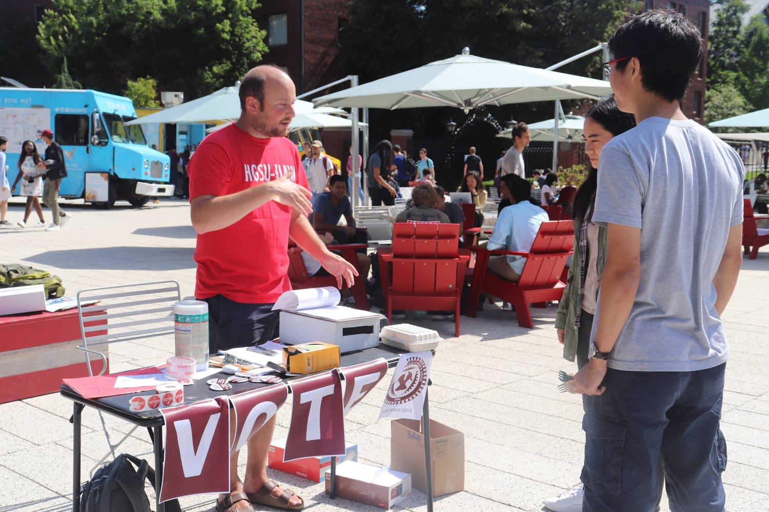 Andrew Bergman, a member of the Executive Board of the Harvard Graduate Students Union, converses with two students on the Science Center Plaza.