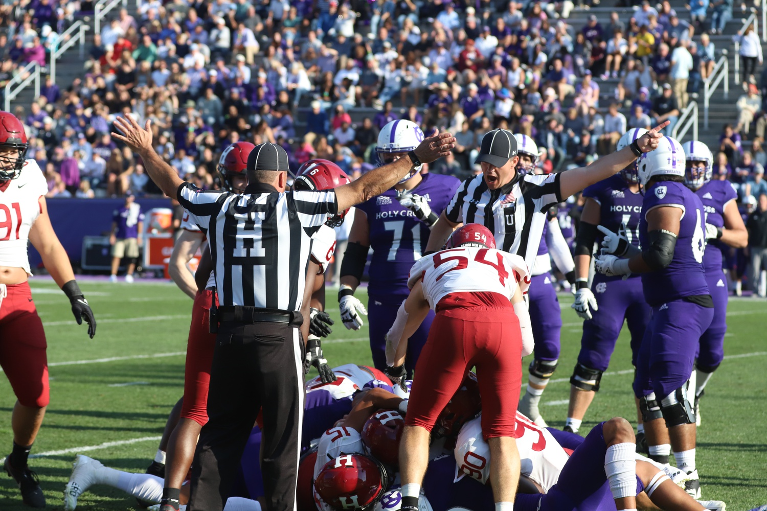 The Crimson and Crusaders fight for a loose ball on the turf after a fumble by Holy Cross sophomore wide receiver Jalen Coker. Ultimately, Harvard sophomore defensive lineman Nate Leskovec would emerge victorious from the dogpile and recover the fumble.