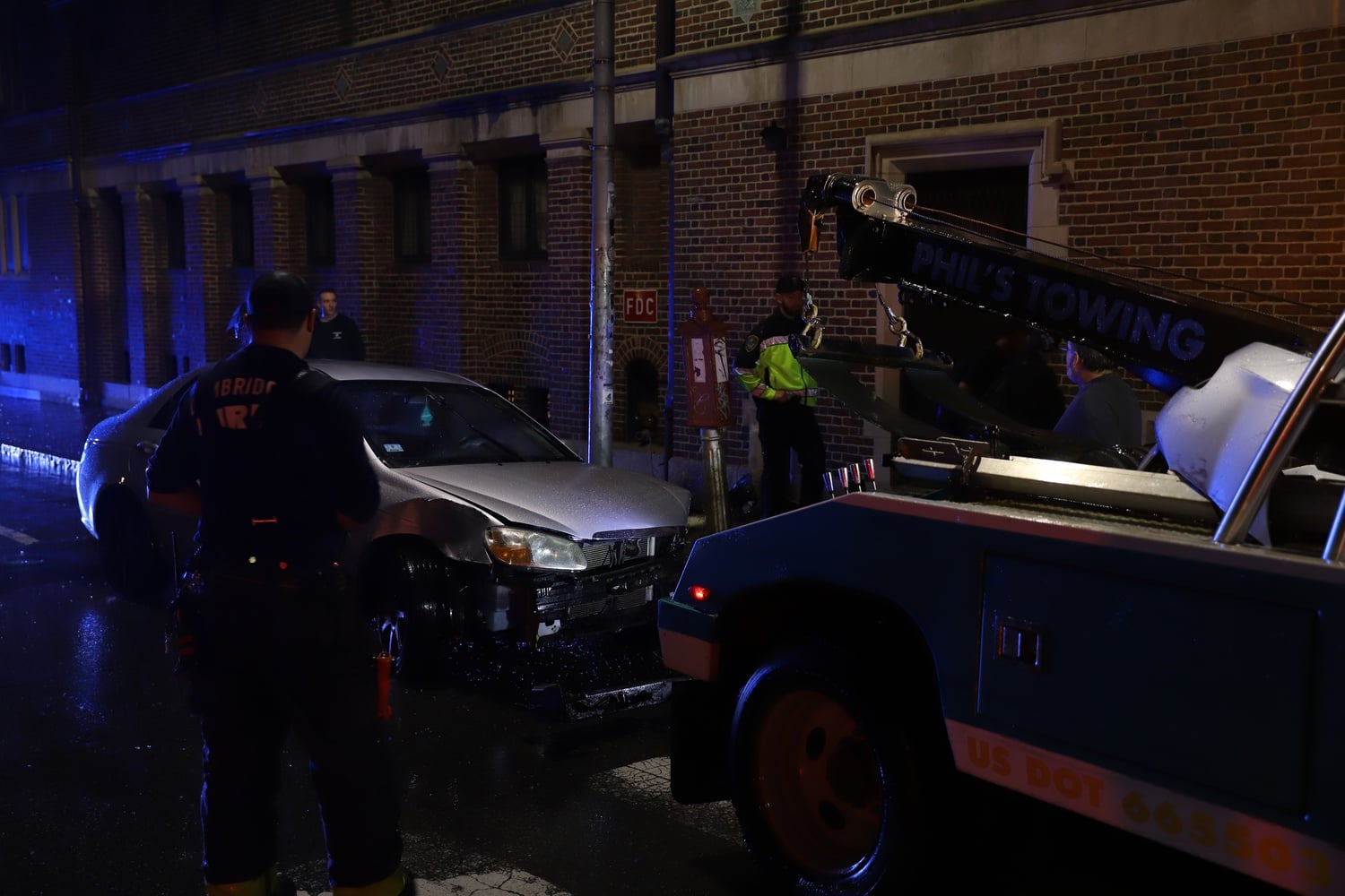 A tow truck removed the gray sedan after it crashed into the Harvard Lampoon building.