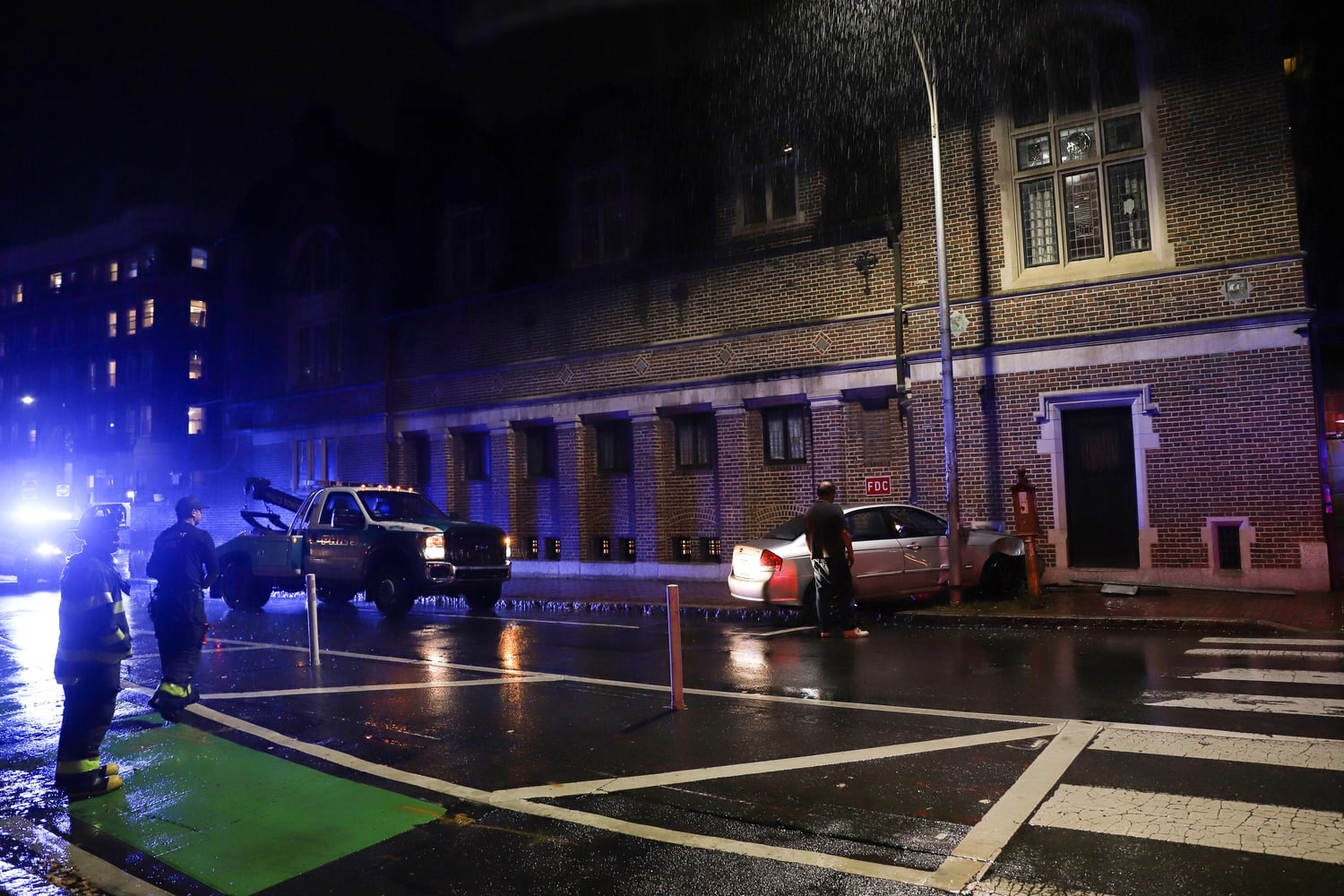 Emergency personnel at the scene after a car crashed into the Harvard Lampoon building Sunday night.