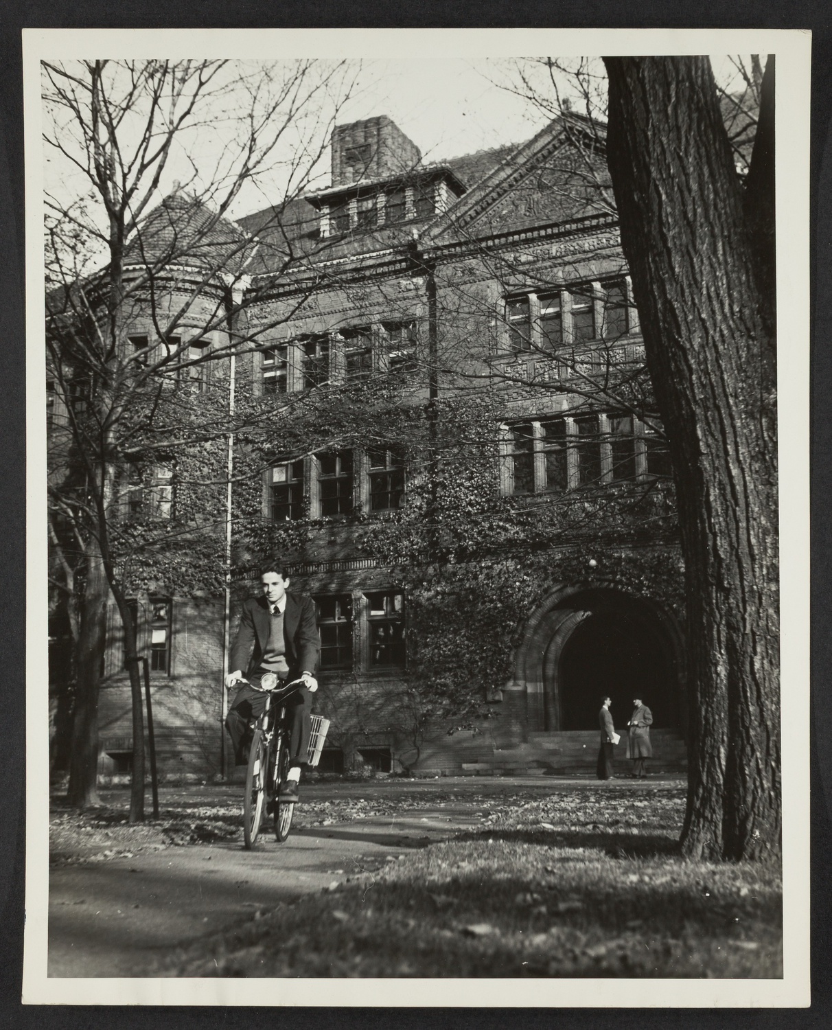 Student riding bike in front of Sever Hall.