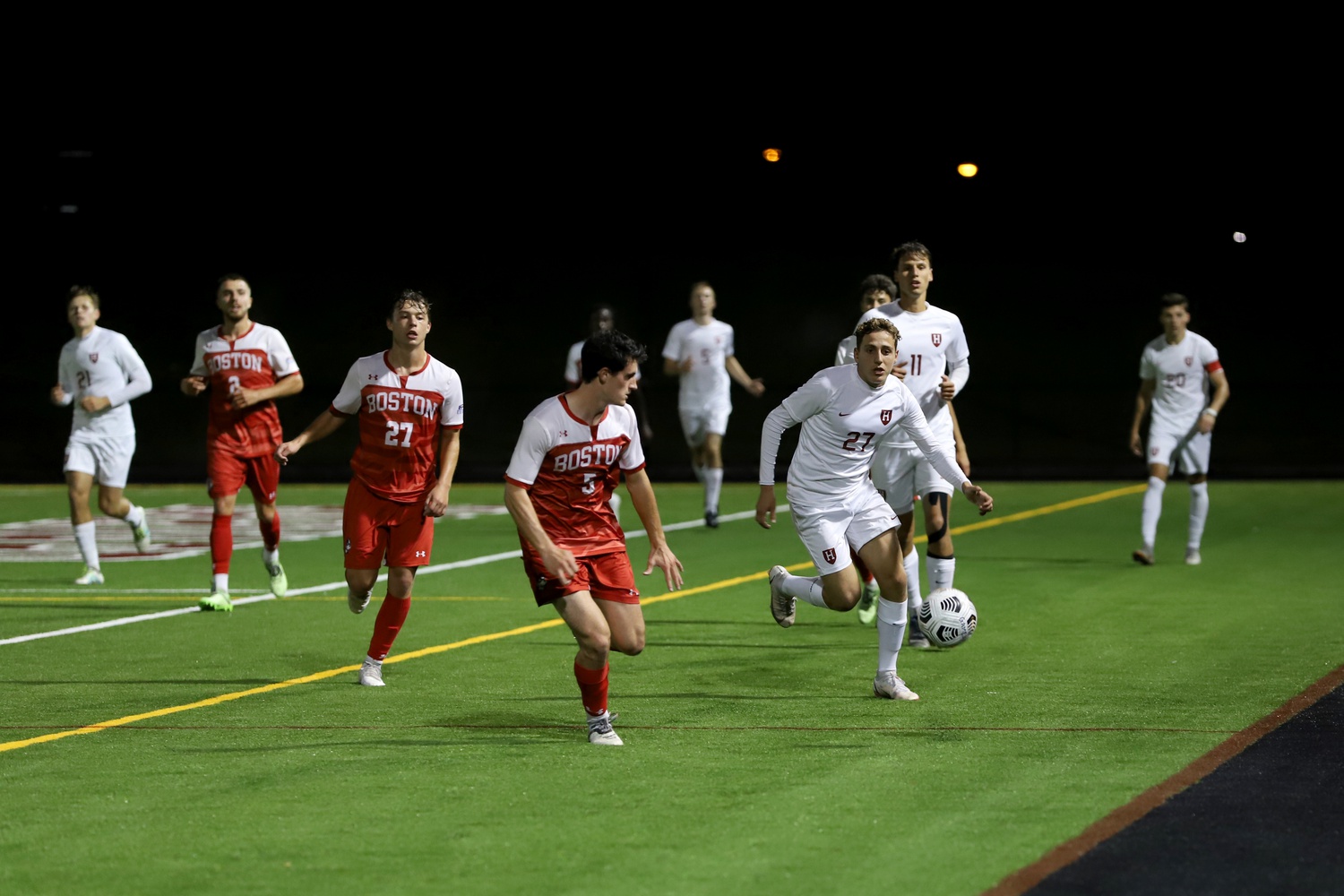 First-year forward Alessandro Arlotti controls a pass as junior forward Martin Vician watches on in a matchup against Boston University. The pair were vital in Harvard’s late rally vs. No.24 Cornell as both scored and assisted.