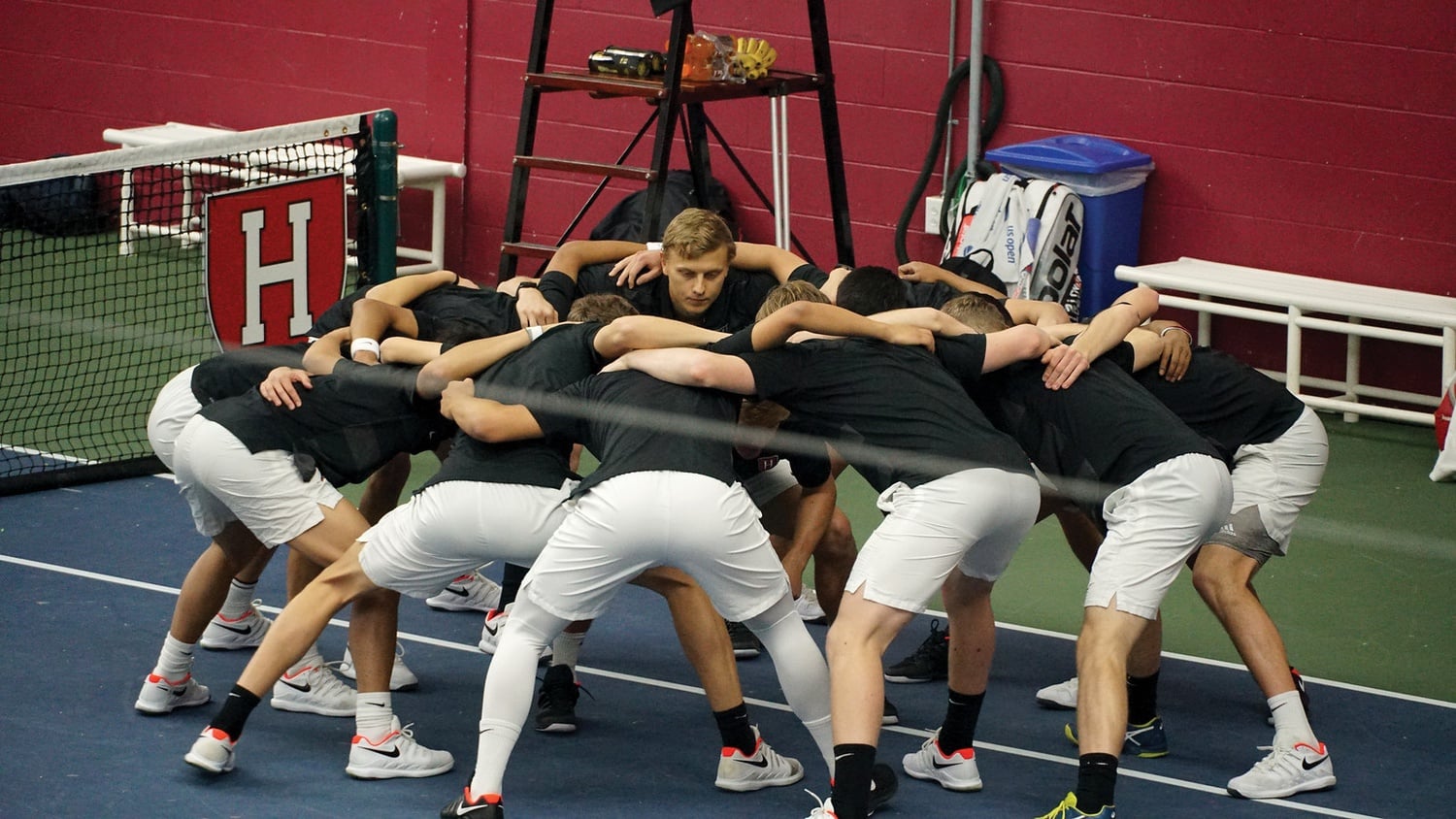 The Harvard men's tennis team, pictured huddling before a February 2020 match,  found success in the Intercollegiate Tennis Association's Northeastern Region Championships in Philadelphia, Penn., beginning Oct. 14.