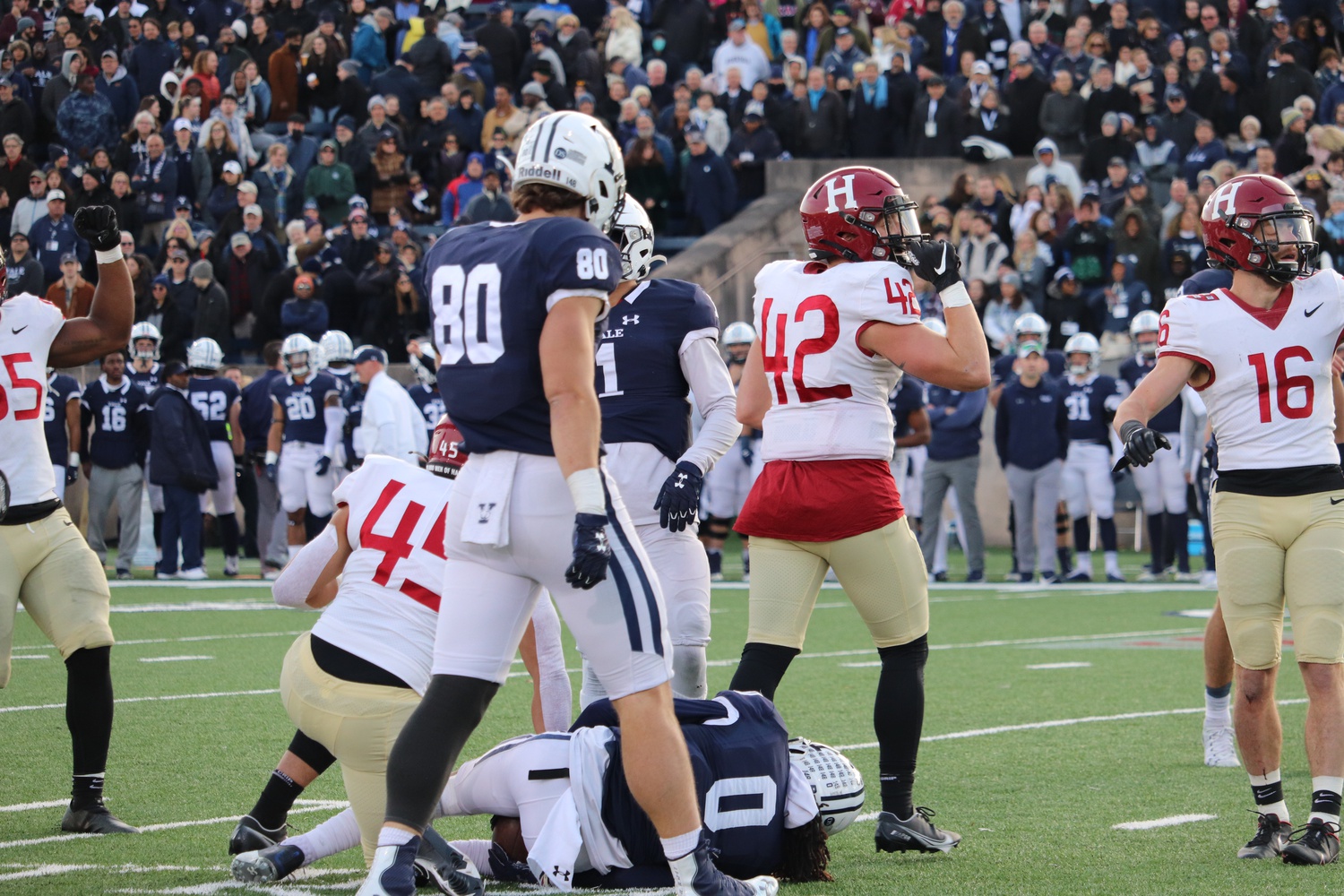 The Harvard defense stifles Yale 's series of laterals on the final play to seal the 34-31 victory.