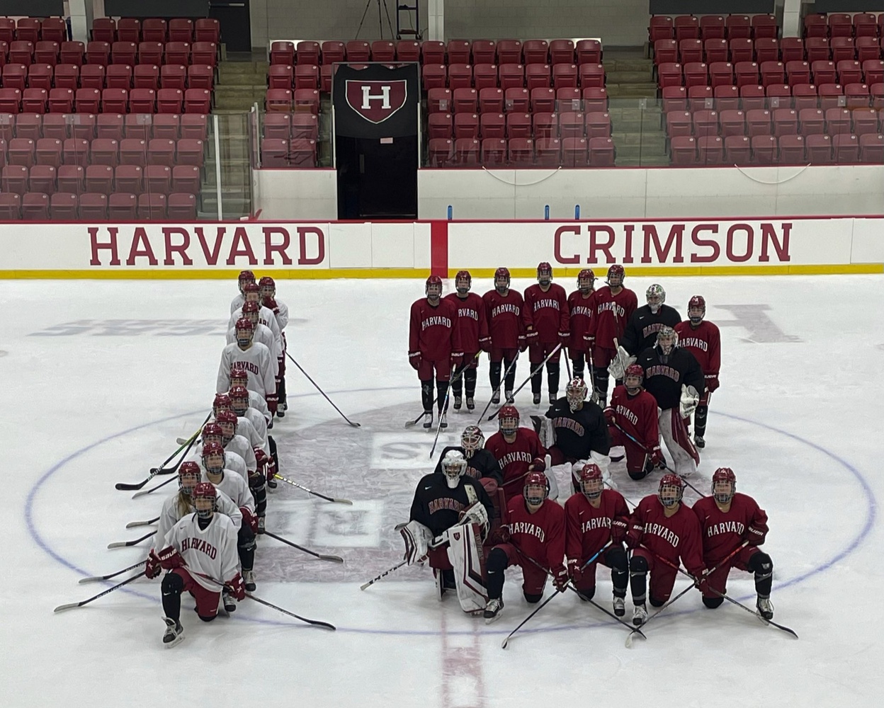 Crimson women's hockey comes together for a team photo in the shape of a 12 at practice. Harvard coaches Katey Stone and Lee-J Mirasolo have pushed for gender equity via tournament expansion for years, and this season, the whole Crimson squad is rallying behind the movement to expand the NCAA Tournament to 12 teams.