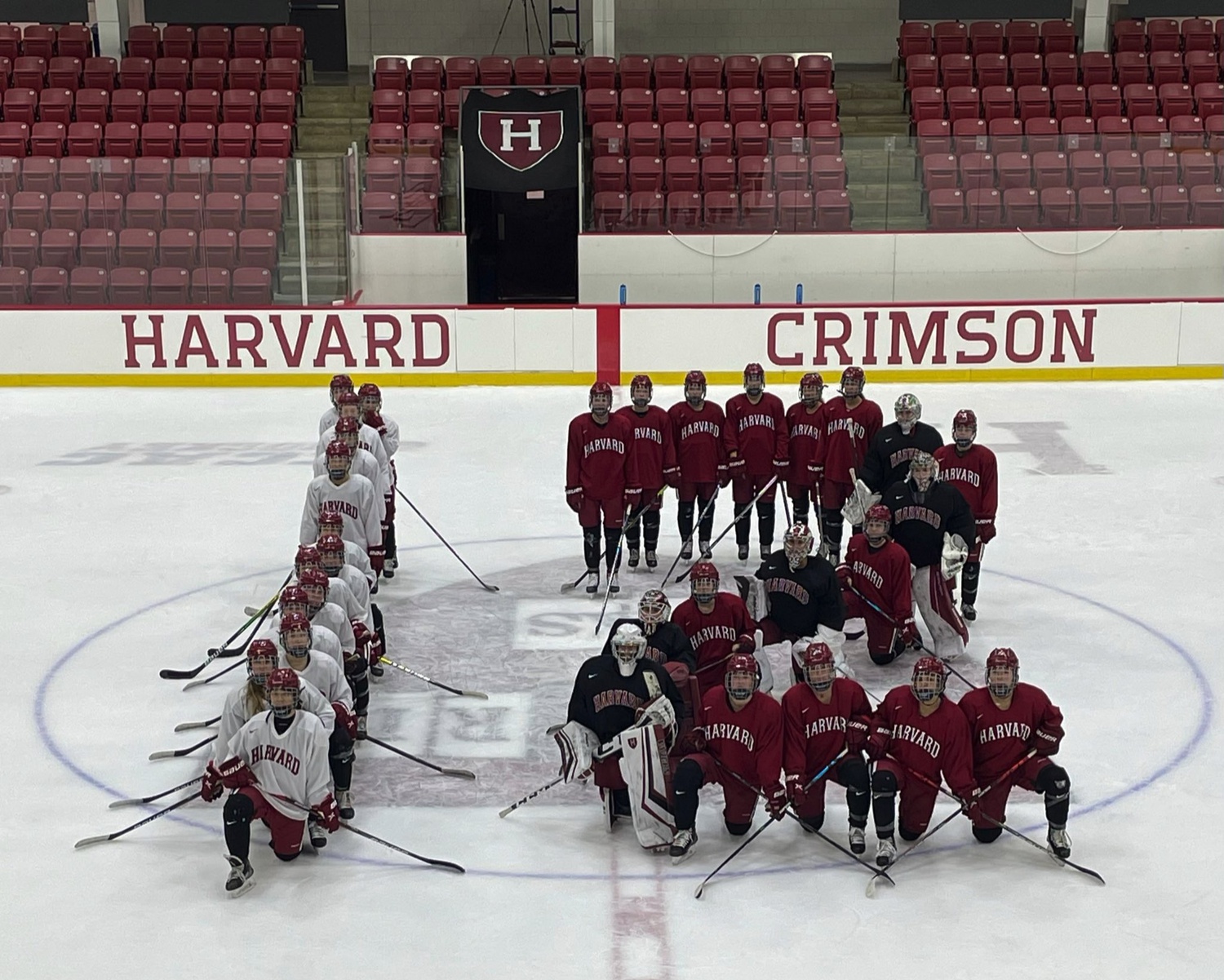 Crimson women's hockey comes together for a team photo in the shape of a 12 at practice. Harvard coaches Katey Stone and Lee-J Mirasolo have pushed for gender equity via tournament expansion for years, and this season, the whole Crimson squad is rallying behind the movement to expand the NCAA Tournament to 12 teams.