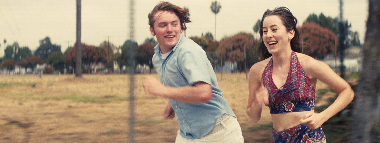 Cooper Hoffman stars as Gary Valentine (left) and Alana Haim stars as Alana Kane (right) in "Licorice Pizza" (2021), directed by Paul Thomas Anderson.