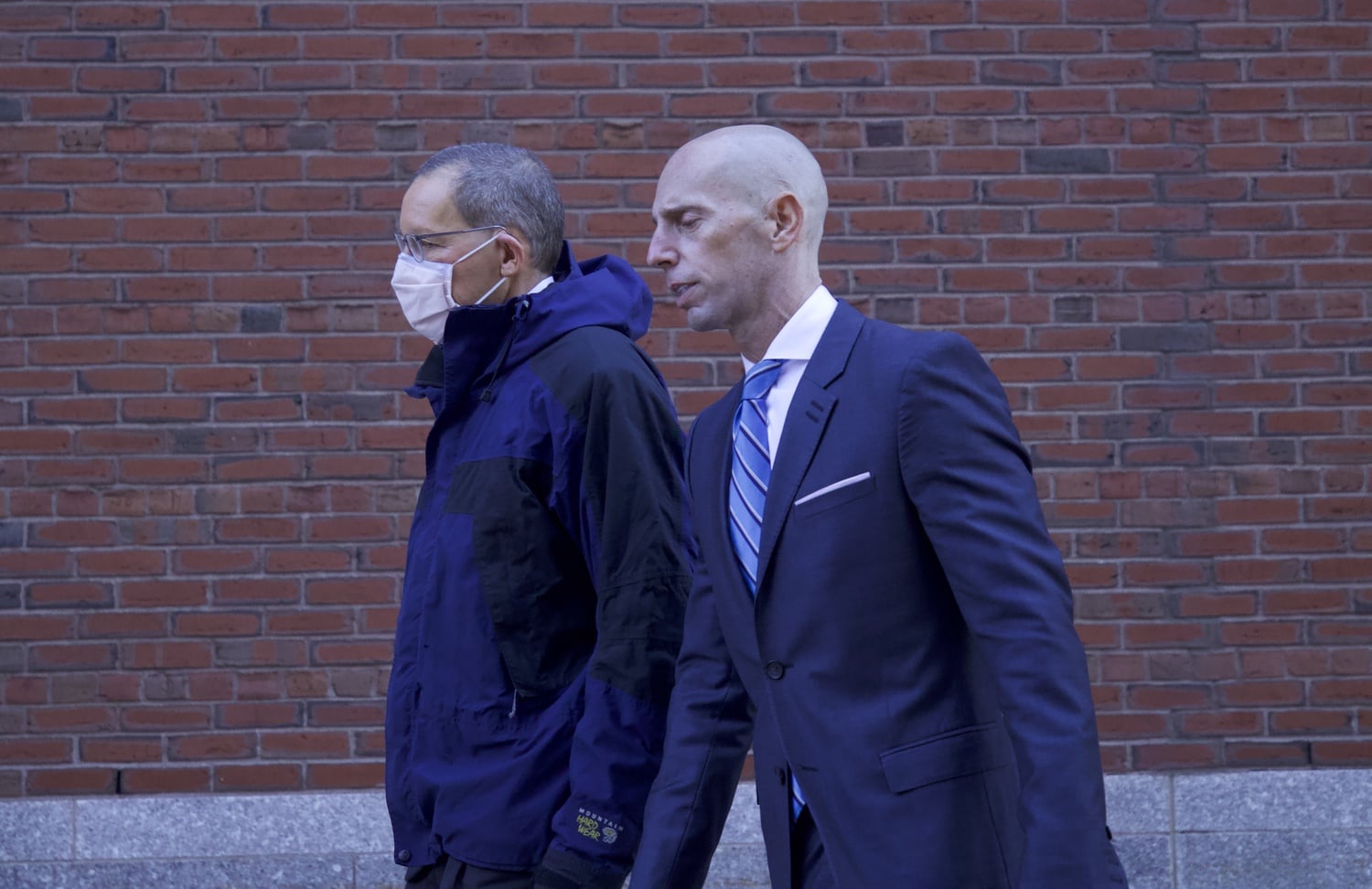 Harvard professor Charles M. Lieber, left, walks away from the John J. Moakley United States Courthouse on Dec. 17 alongside his attorney, Marc L. Mukasey.