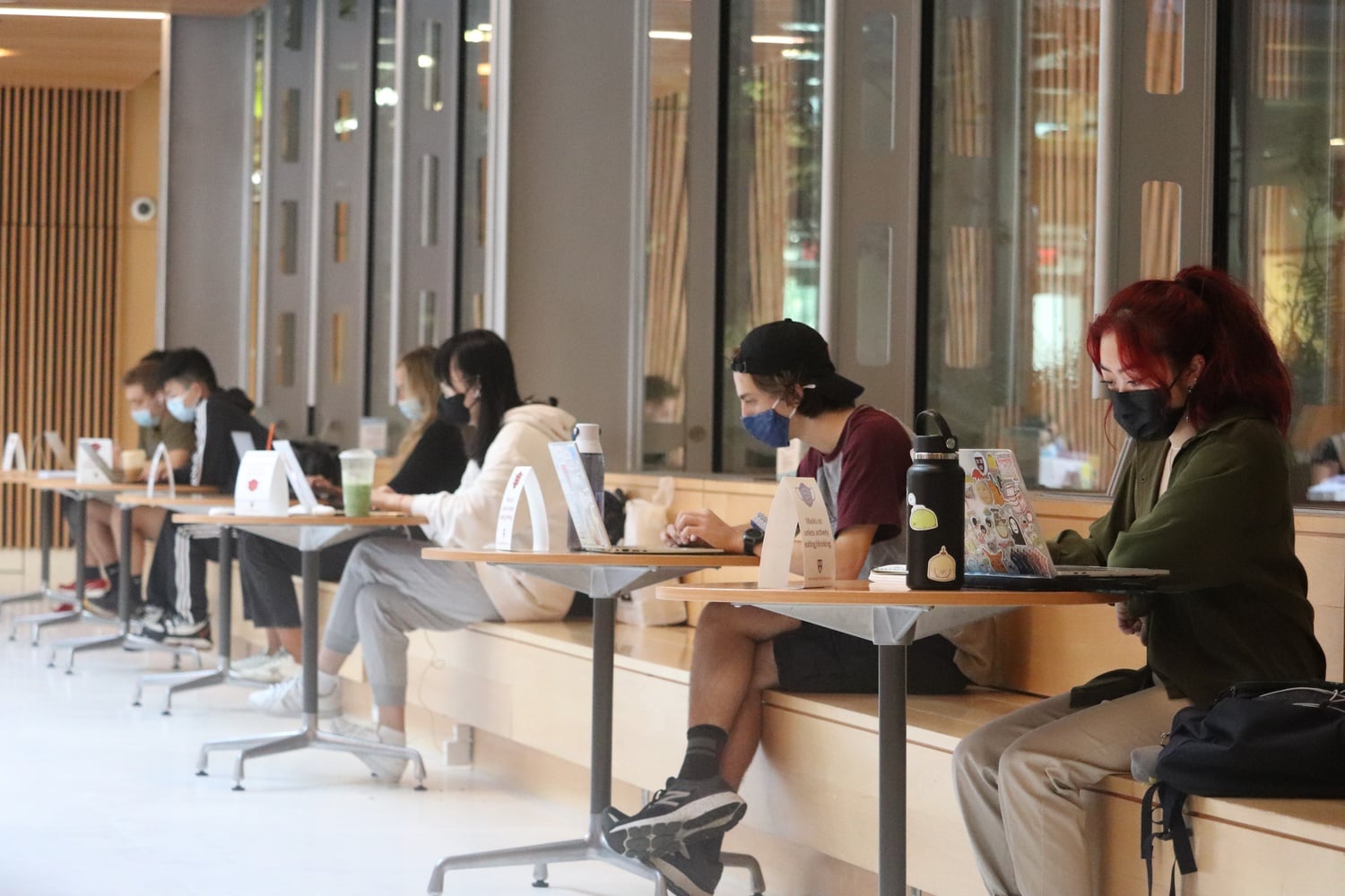 Students sit masked and socially distanced in the Smith Campus Center during the pandemic.