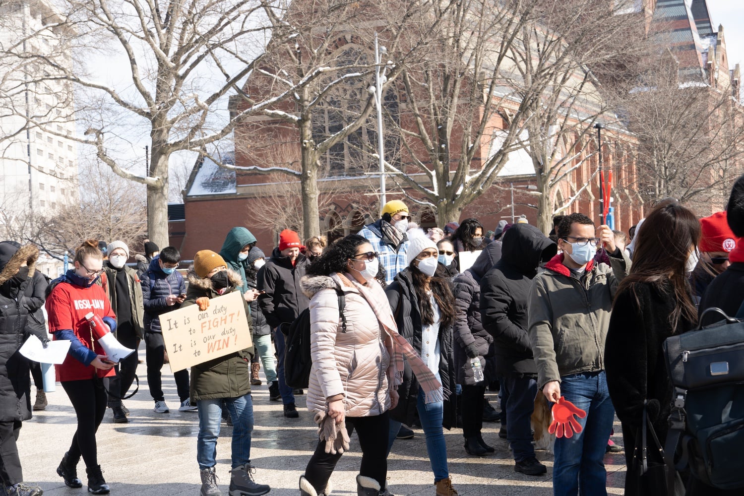 Demonstrators who attended the walkout created signs showing their support for three graduate students who filed a lawsuit alleging that Harvard mishandled Title IX cases.