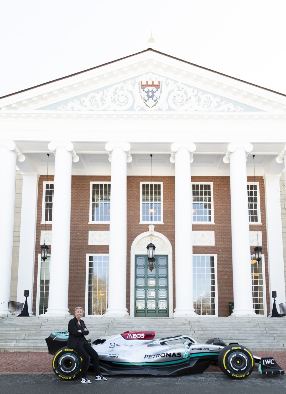 Professor Anita Elberse, who teaches "The Business of Entertainment, Media, and Sports" at HBS, poses with the newest Mercedes AMG Petronas Formula One race car in front of Baker Library.