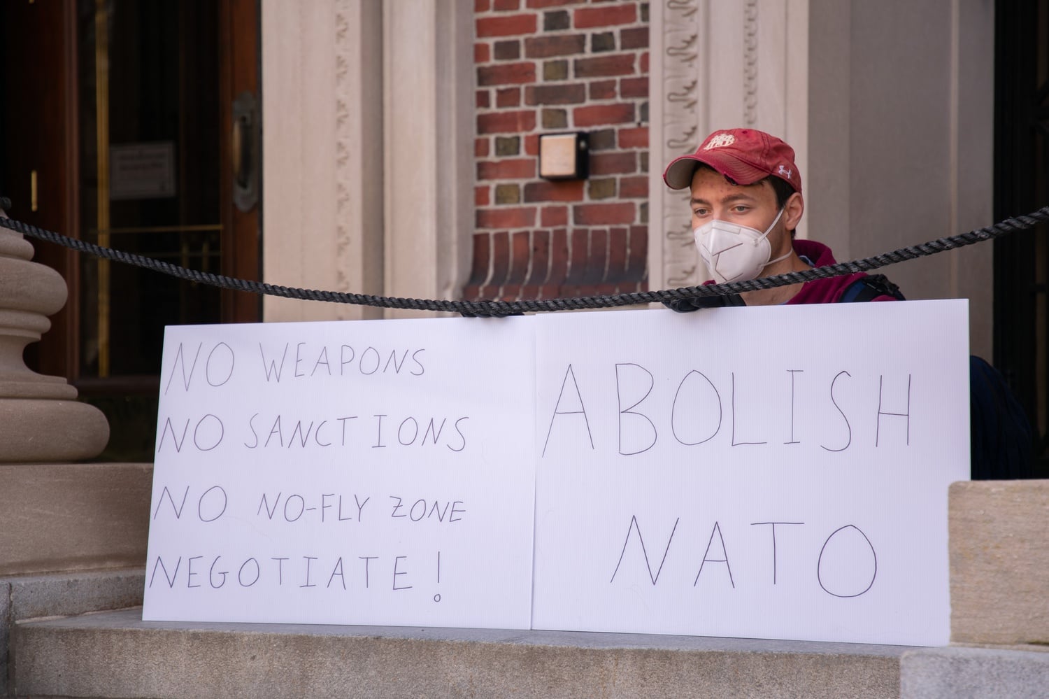 Michael A. Miccioli '22 displayed signs at the rally calling for no sanctions and the abolition of NATO.