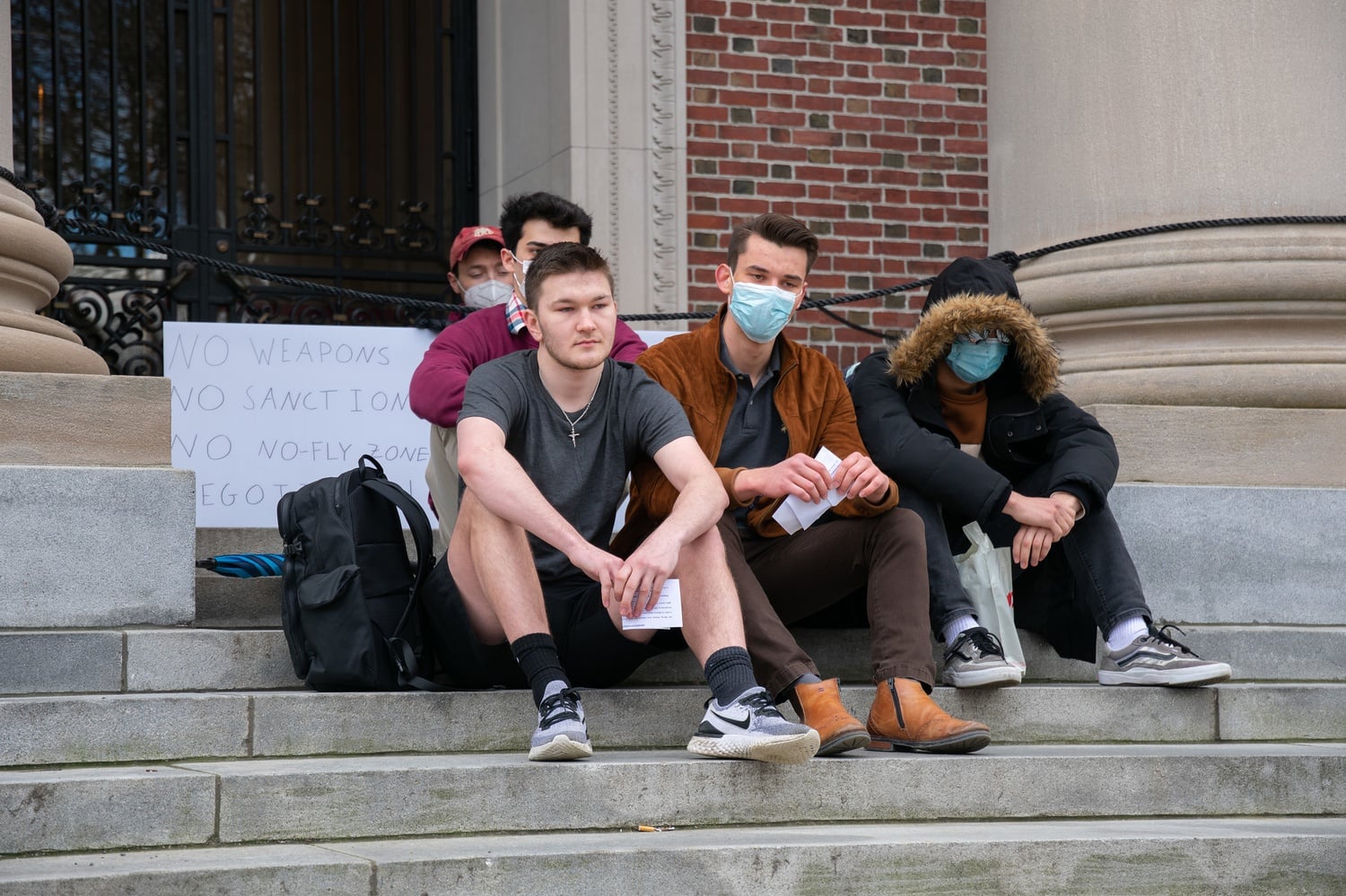 Four rallygoers blocked signs by held up by Michael A. Miccioli ’22 that read “Abolish NATO” and “No Weapons, No Sanctions, No No-Fly Zone, Negotiate!”