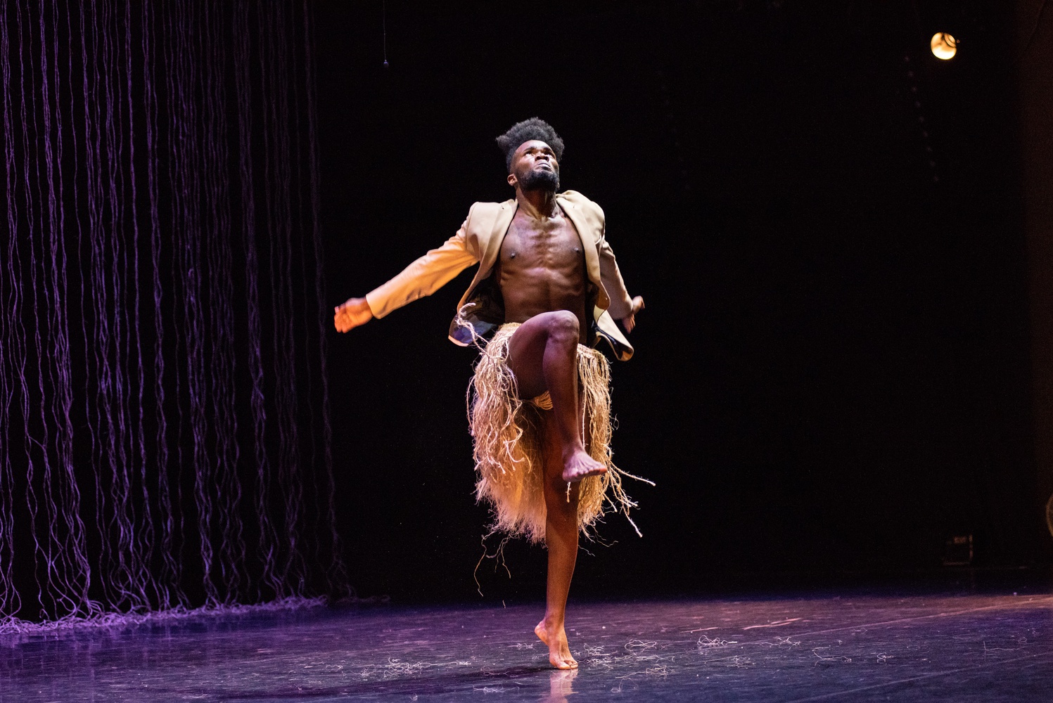 Yeison Moreno Cordoba wears a suit jacket and rope skirt in Sankofa Danzafro’s “Accommodating Lie.”