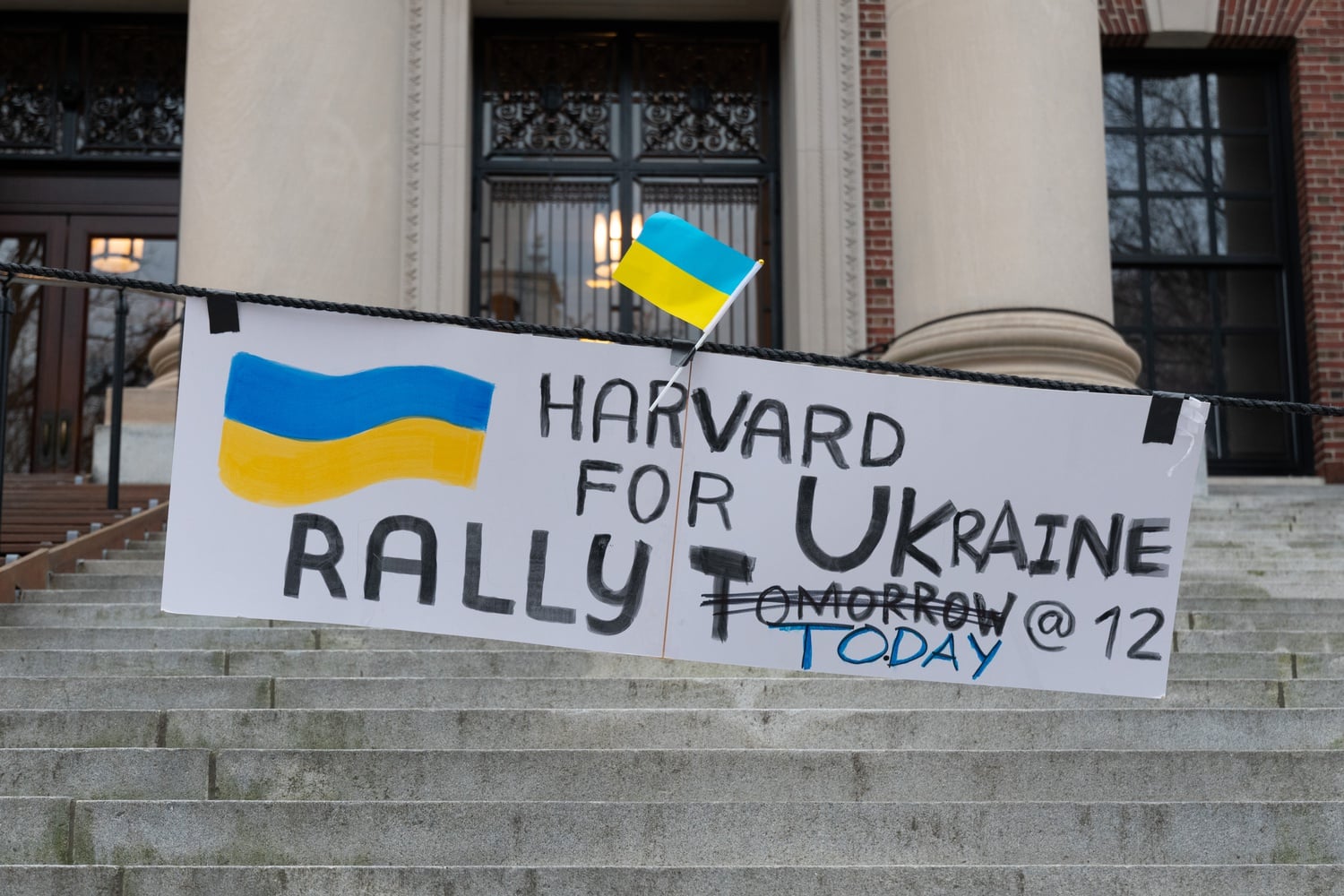 A sign in front of Widener Library raises awareness for a student rally in support of Ukraine.
