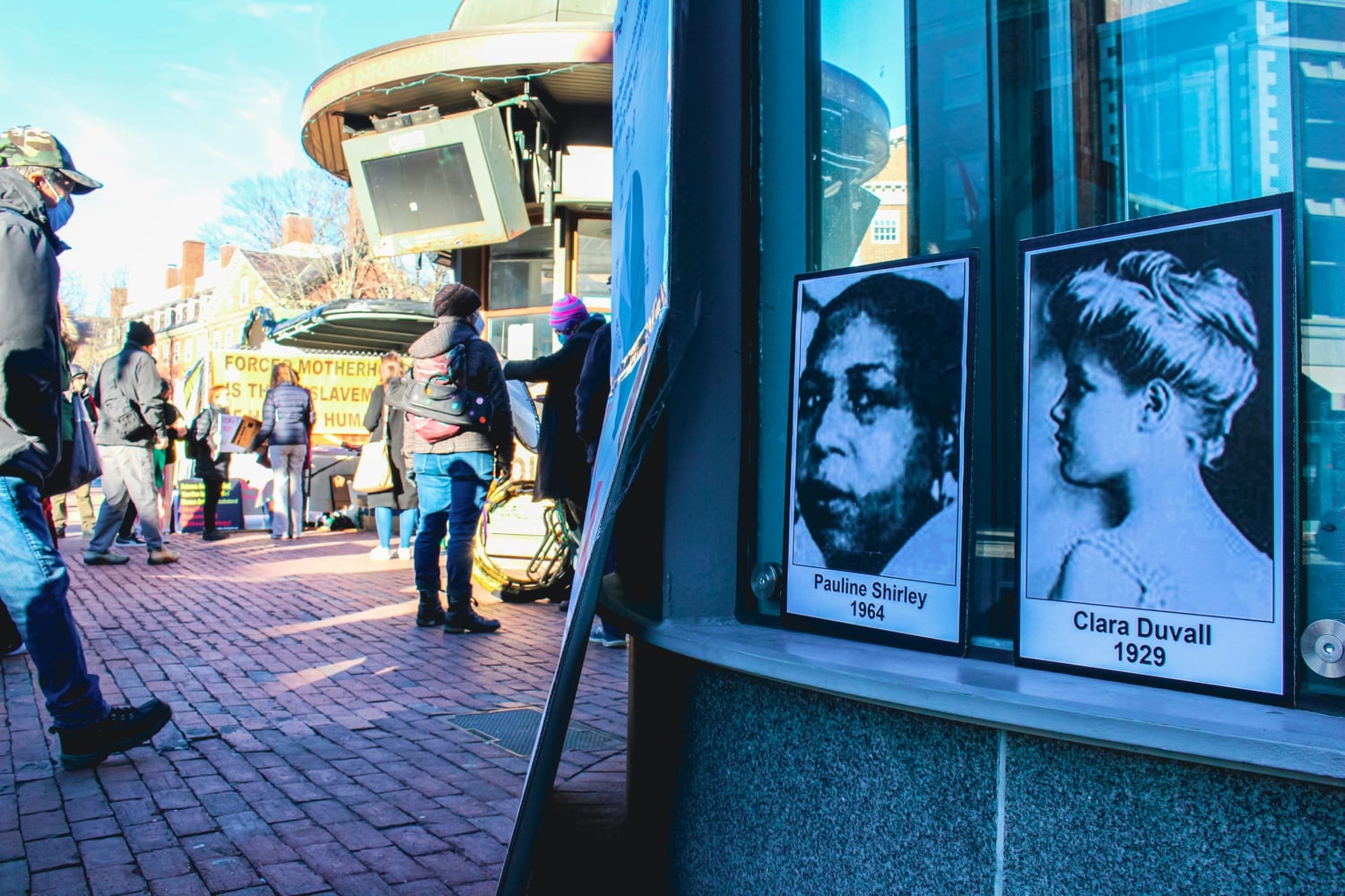 Black-and-white images of women who died from illegal abortion procedures pre-Roe cover the T-station elevator during an abortion rights rally in Harvard Square.