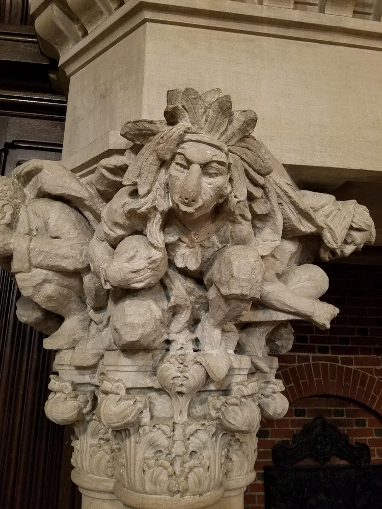 A close-up shot of the purported Indigenous figure with a large headdress, ball in hand, and a ring hanging from its nose.