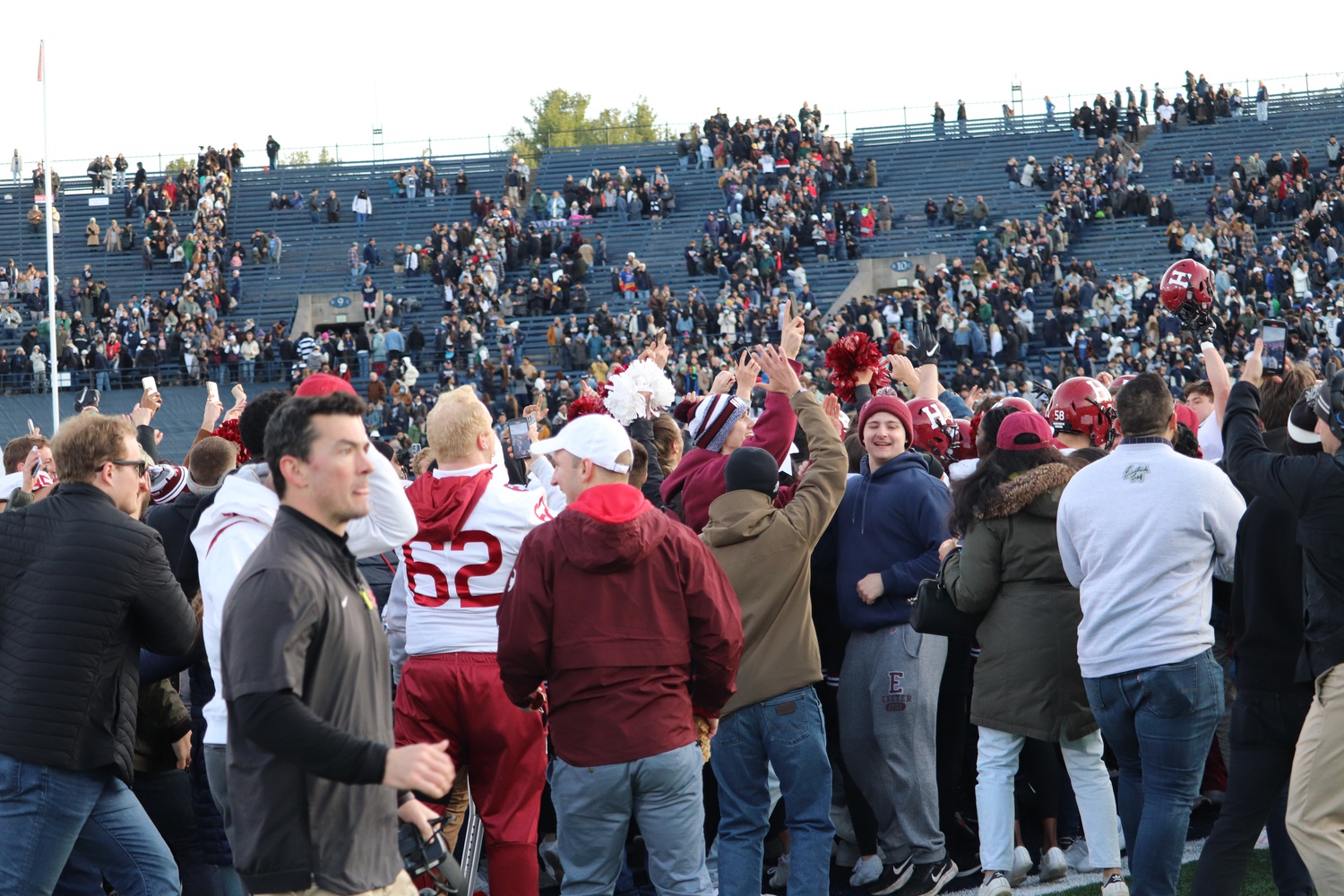 Harvard fans and players spill onto the field at the Yale Bowl after the Crimson's 34-31 victory in the 137th edition of The Game on Nov. 20, 2021.