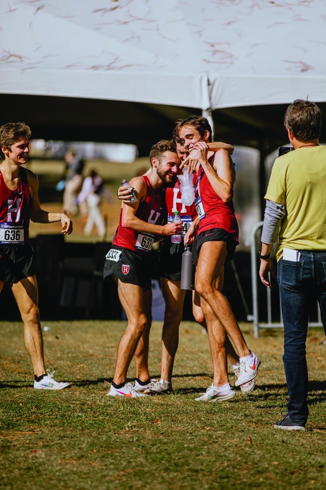 Acer Iverson, Graham Blanks, and Matthew Pereira of the cross country team embrace after the Ivy League Heptagonal Championships on Oct. 30, 2021, where the Crimson finished first. One year later, Iverson and Blanks finished 1-2 in the meet, a first for the Crimson since 1969.