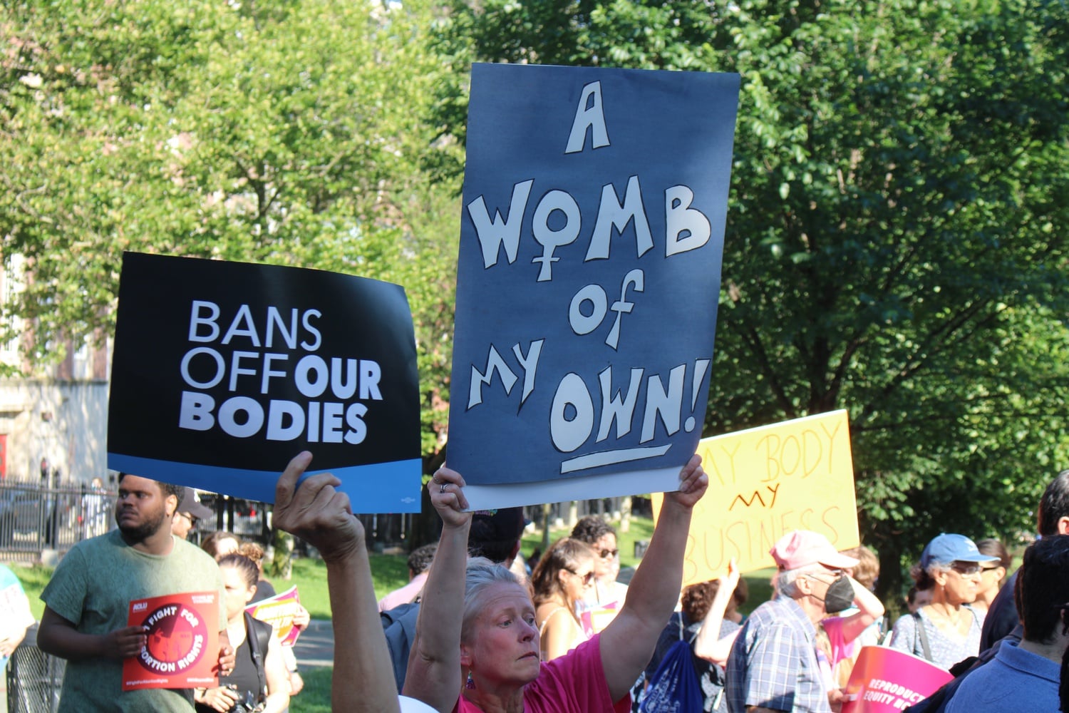 Demonstrators up a sign during a rally in Boston protesting the Court's ruling to overturn Roe v. Wade.