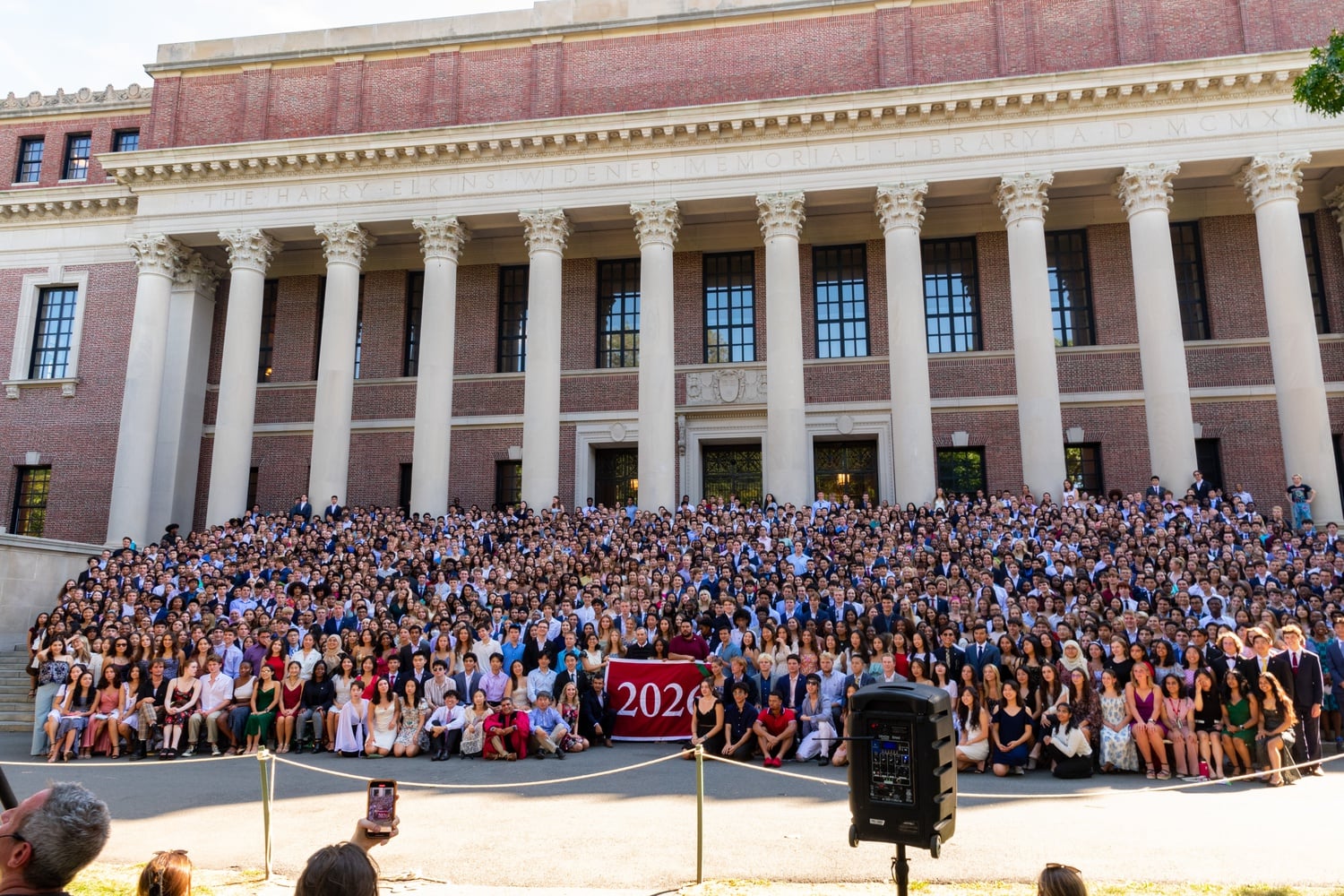 The Class of 2026 gathers for a photo on the steps of Widener library.