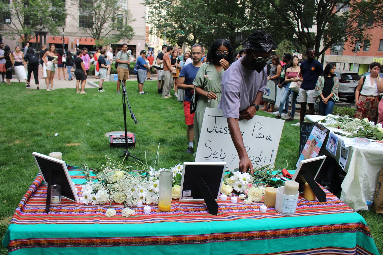 Attendees at the rally for Rodrigo Ventocilla Ventosilla lay flowers at a memorial dedicated to Ventocilla, a Harvard Kennedy School student who died in Indonesia on Aug. 11.