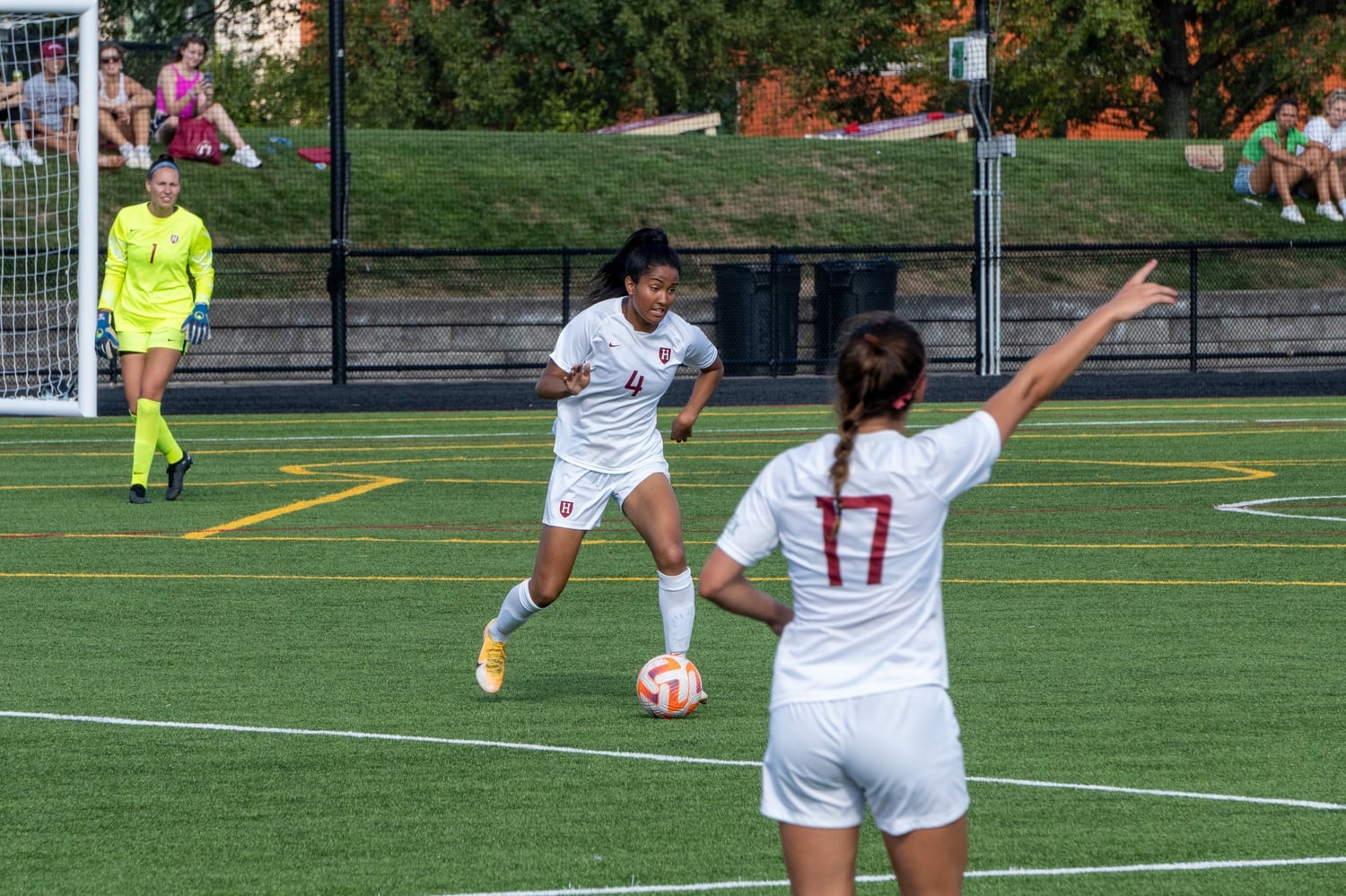 Junior defender Smith Hunter controls the ball with junior Taylor Fasnacht in the foreground and junior goalkeeper Anna Karpenko observing from goal in their match against Northeastern on August 29. Harvard prevailed with a score of 3-2.