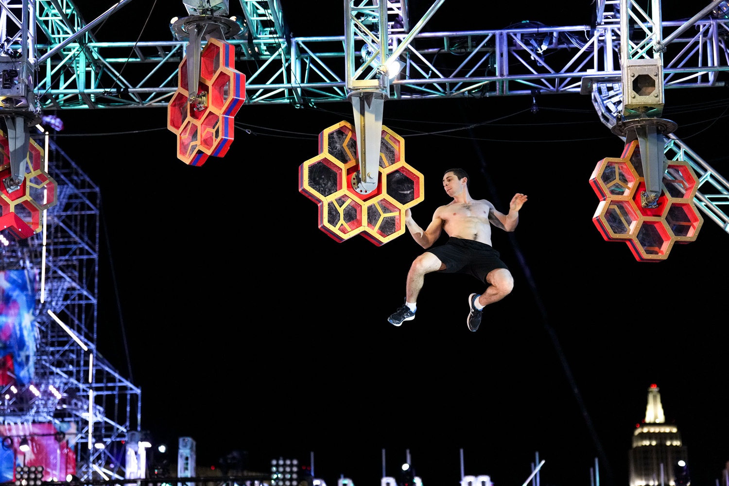 Levin leaps from one handhold to another on the Beehive obstacle.