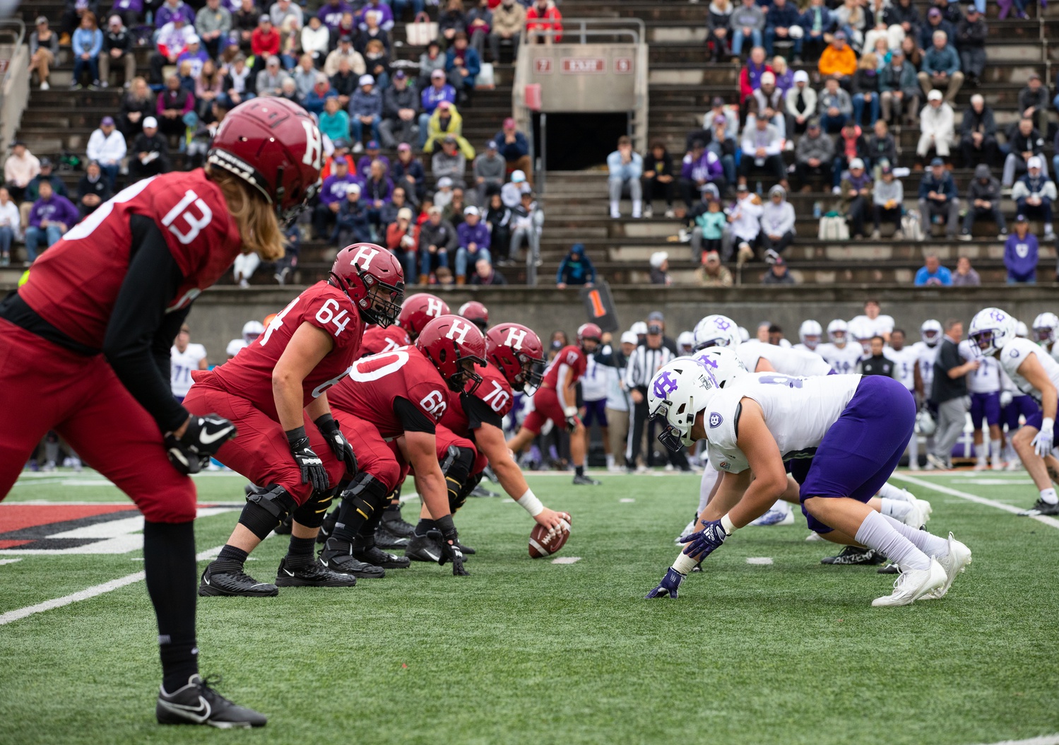 The Harvard offensive line – plus wide receivers Ledger Hatch (13) and Jack Bill (17) – lines up for a snap against Holy Cross on Saturday. The o-line had a solid performance, resulting in two rushing touchdowns.