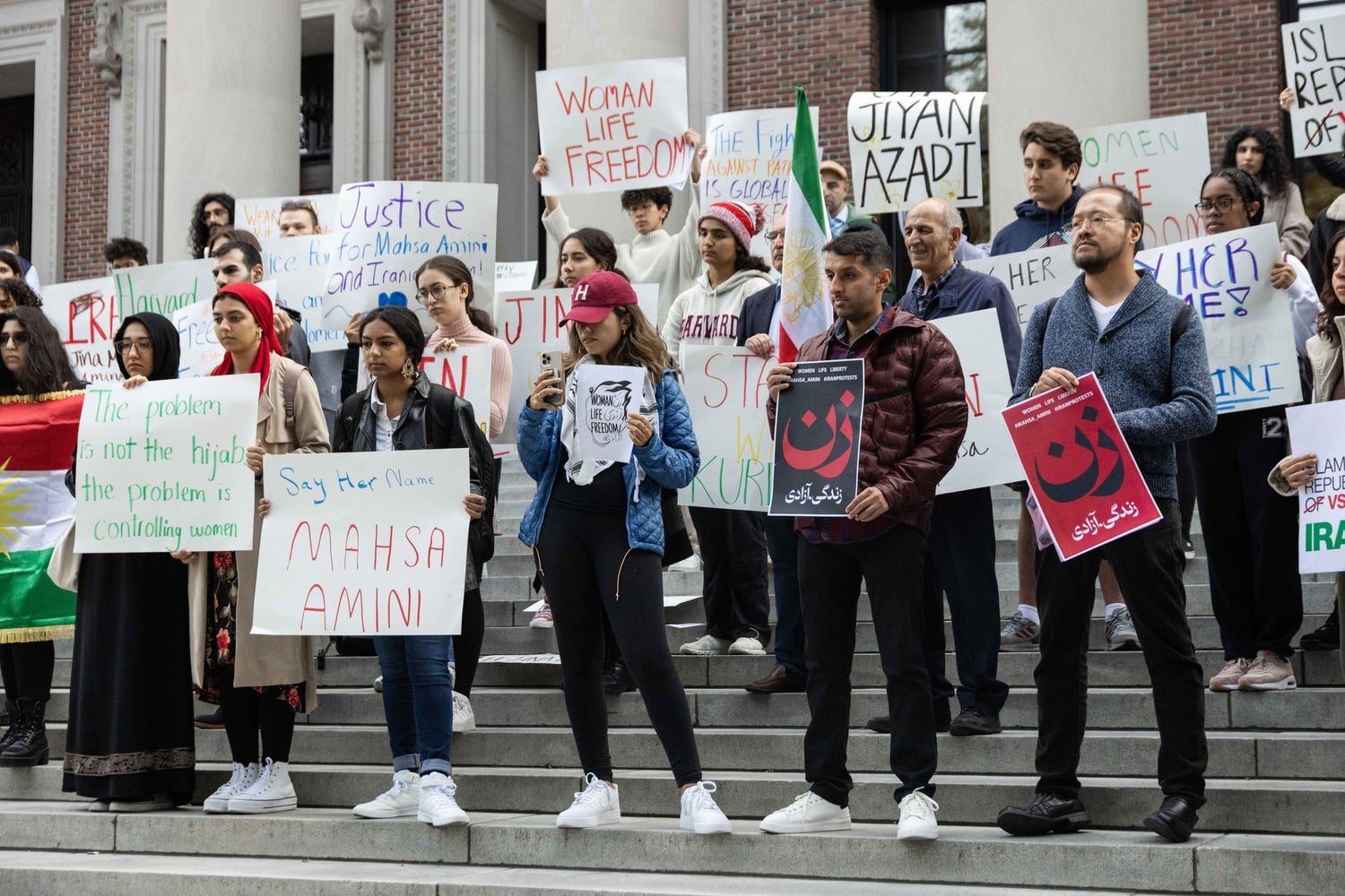 Attendees of Friday's rally held posters calling for justice for Zhina Mahsa Amini, a young Iranian woman who died in police custody last month.
