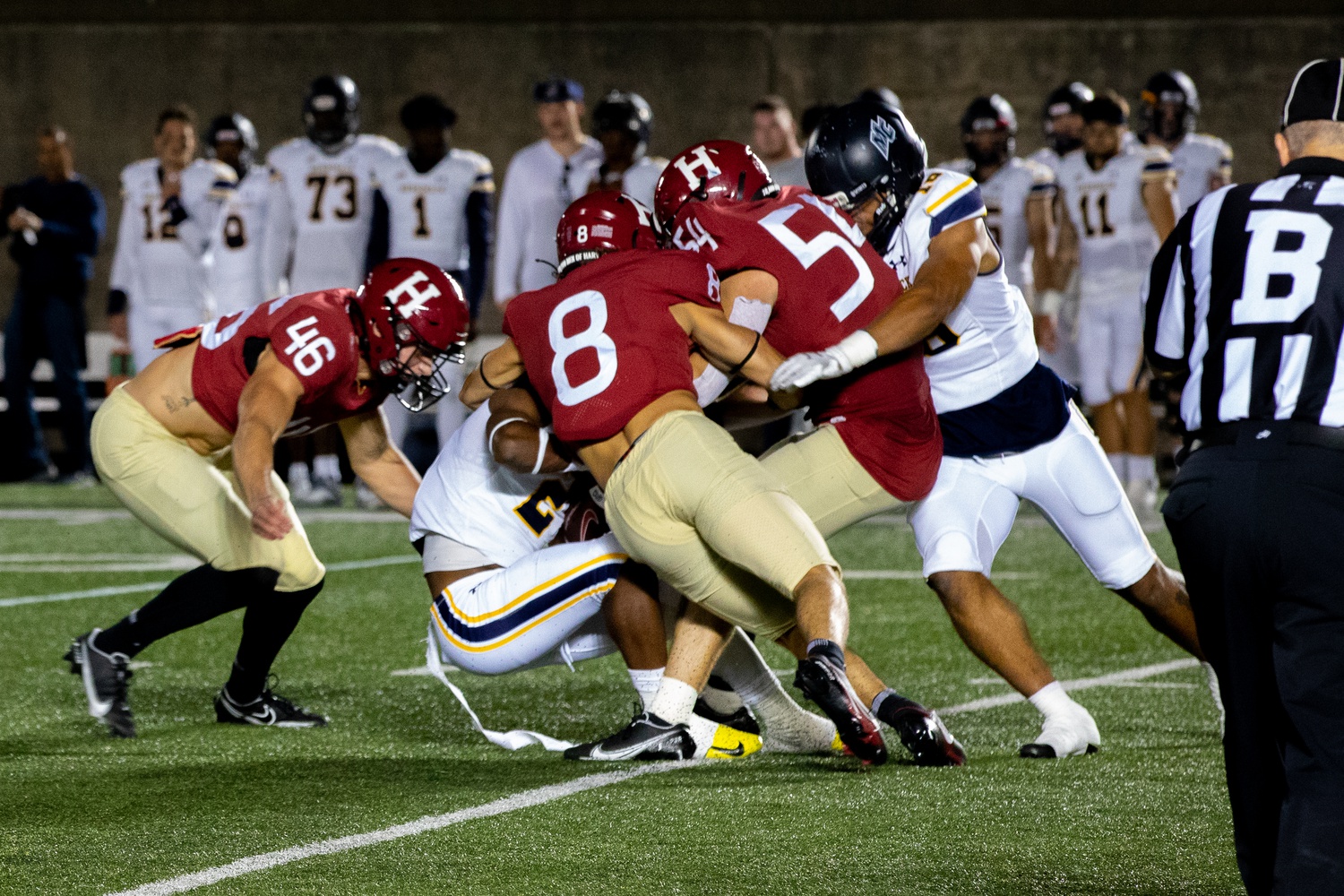 First-year linebacker Jack Kirkwood, sophomore defensive back Riley Jenne, and senior linebacker Jack McGowan combine for a tackle in a 28-21 (OT) victory over Merrimack on Sept. 16.