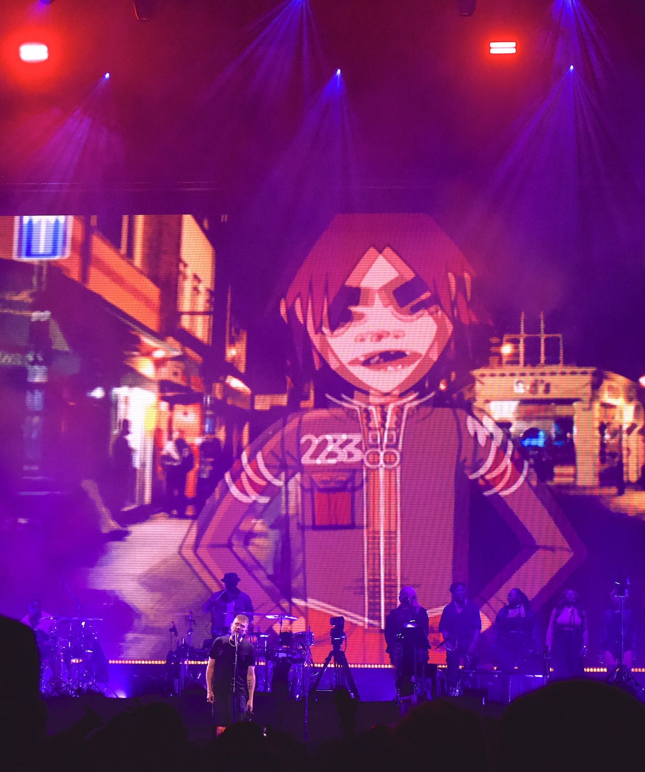 Albarn performing with animated bandmate Murdoc Niccals in the background.