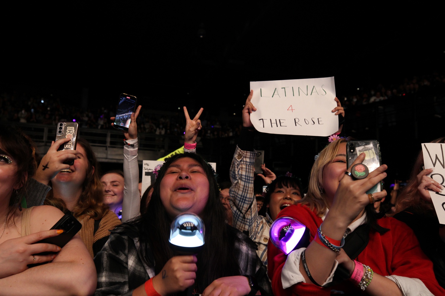 Black Roses — fans of the band — holding up signs and cheering the band members on.
