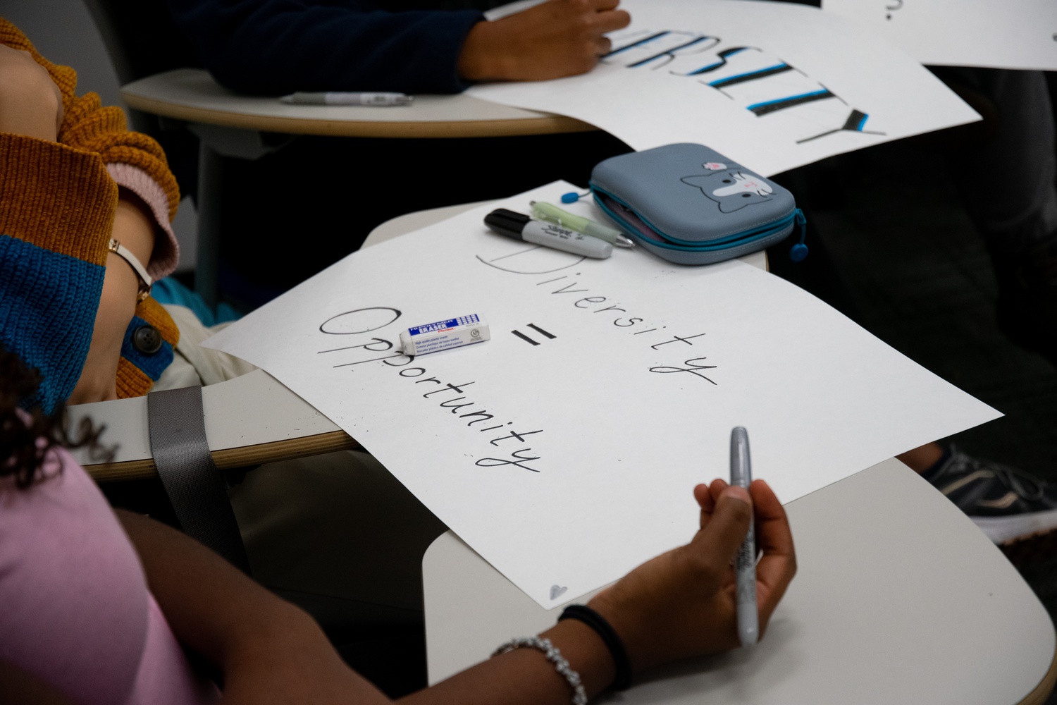 A student makes a sign for a rally to defend affirmative action.