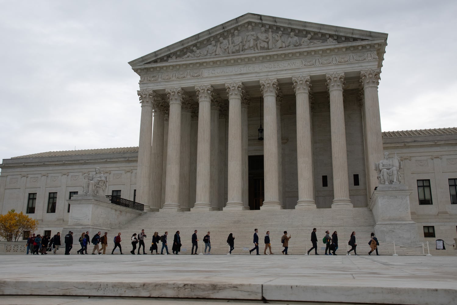 Members of the public who waited in line to attend the arguments walk across the plaza on their way to the Courtroom.