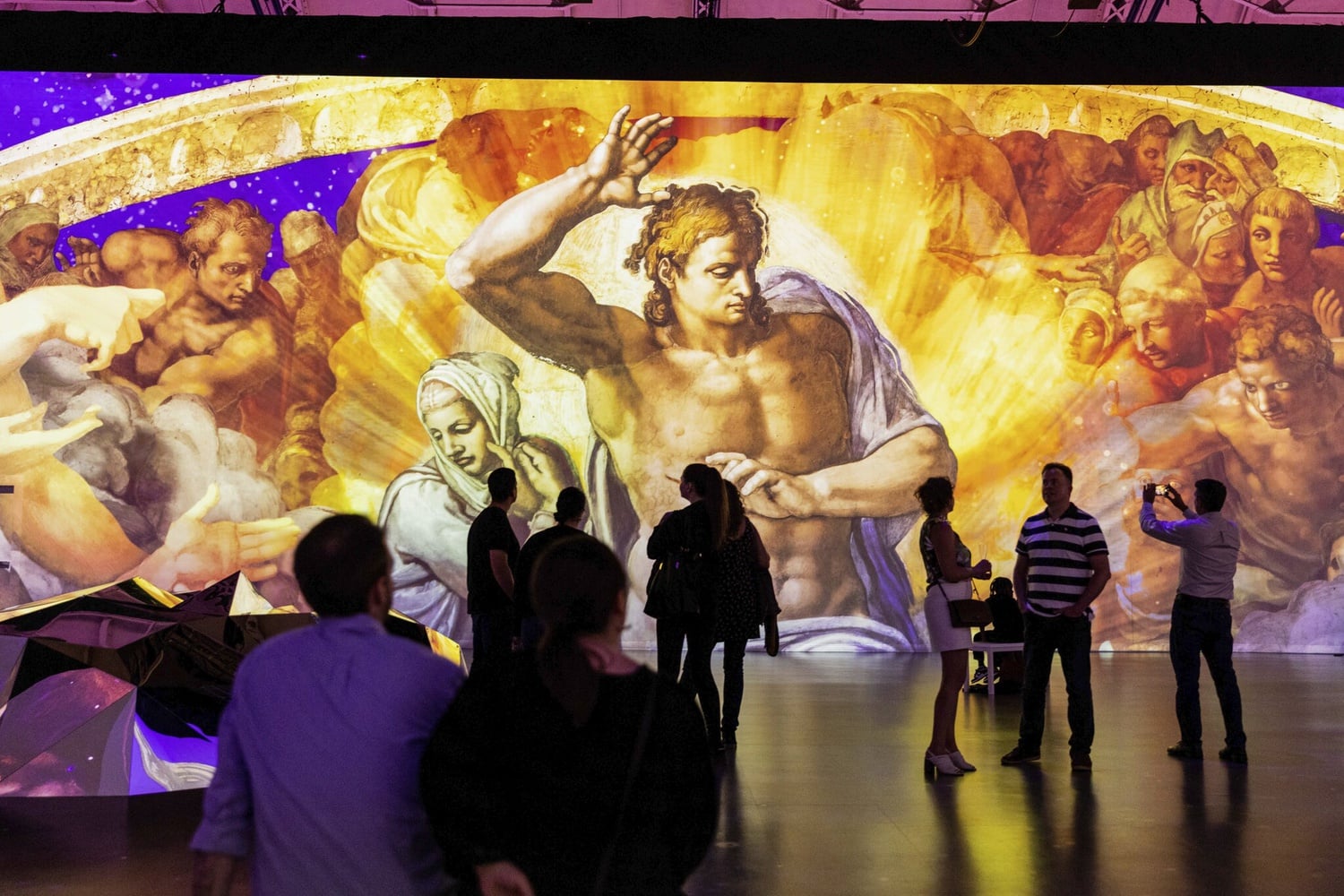 Crowds observe “The Last Judgment” by Michelangelo, featured in “Immersive Vatican.”