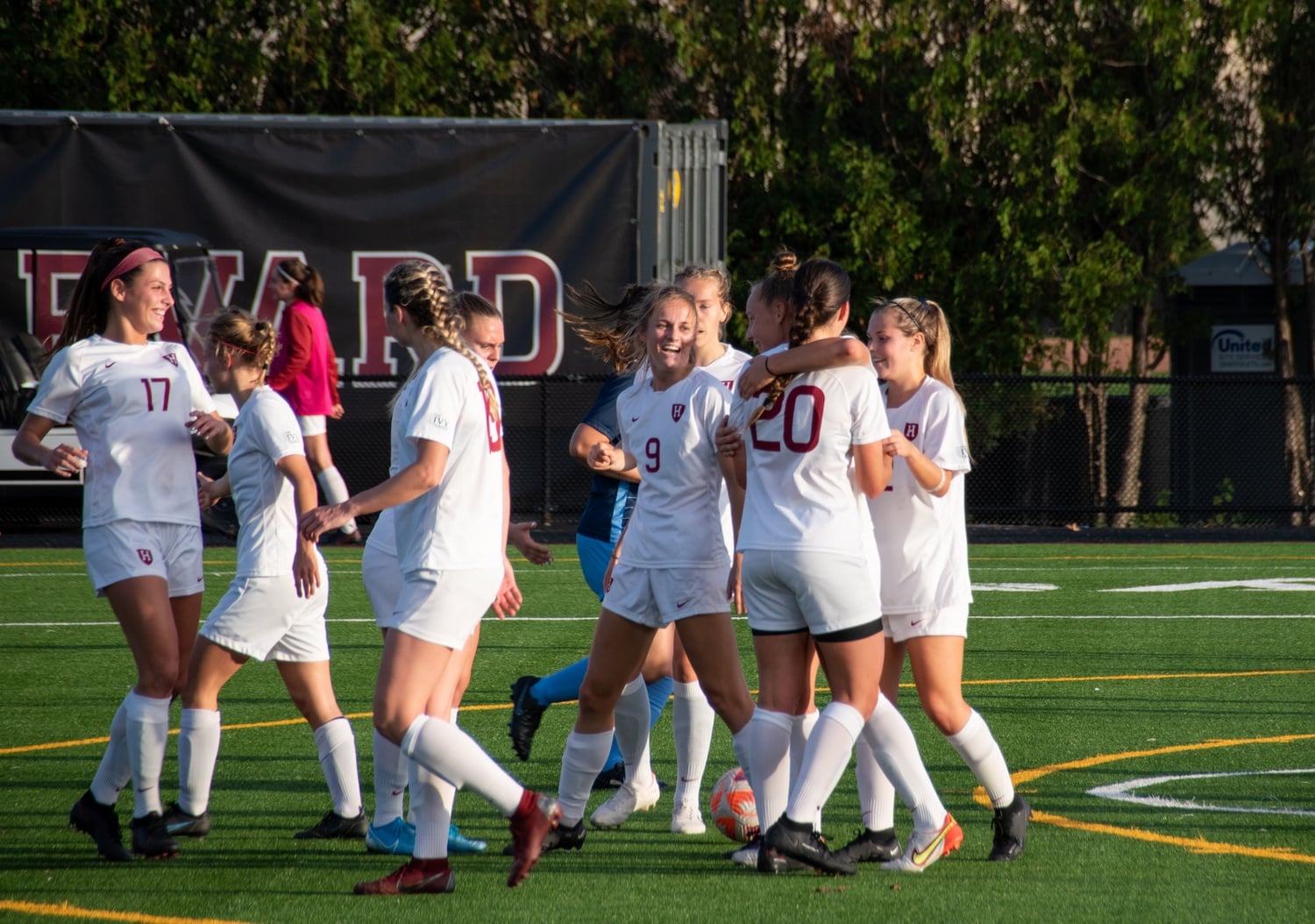 Harvard swarms senior Angela Caloia to celebrate after she scores on an assist from senior Hannah Griffin on senior night.